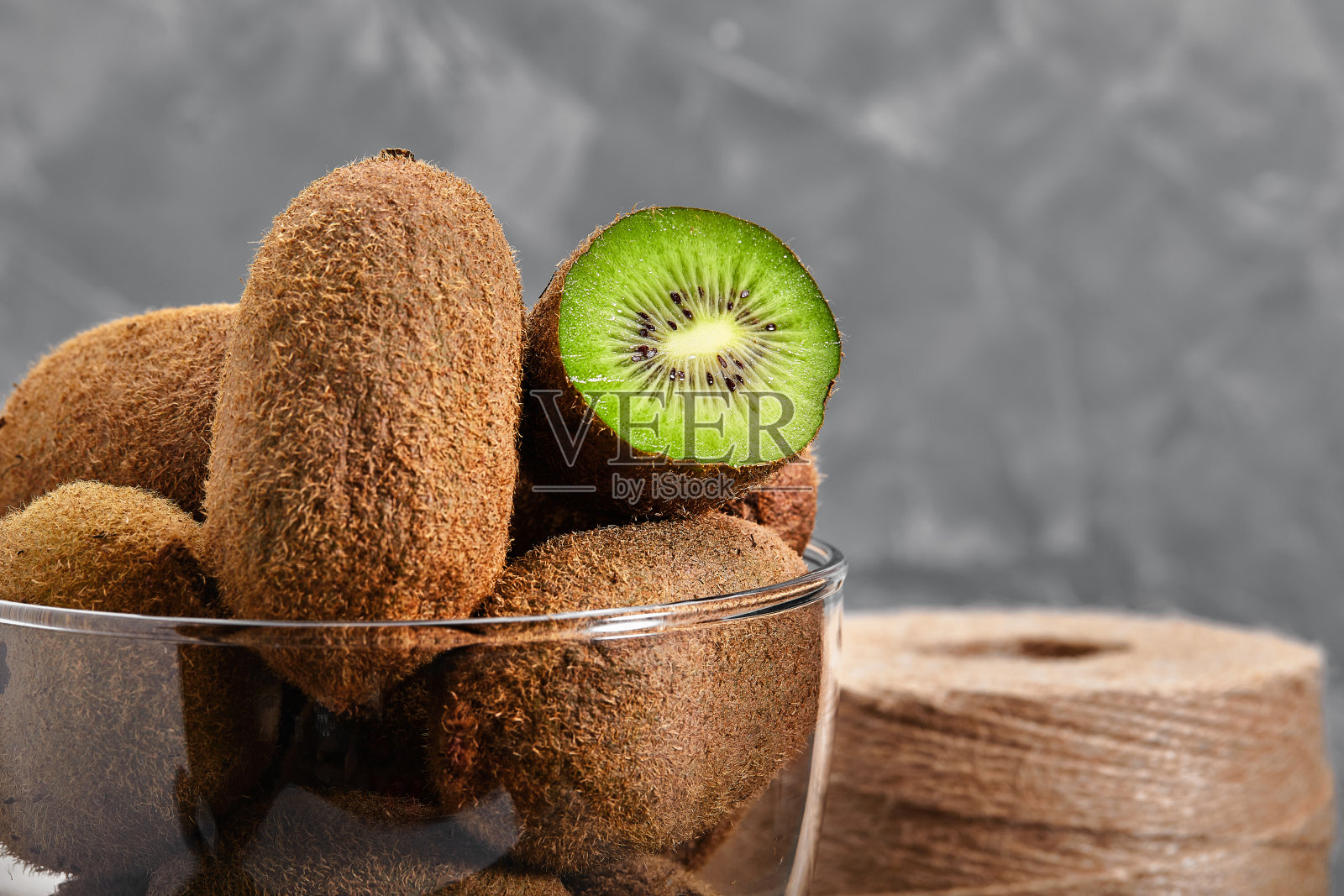 猕猴桃半切于玻璃碗中，背景为暗黑色，角度视角照片摄影图片