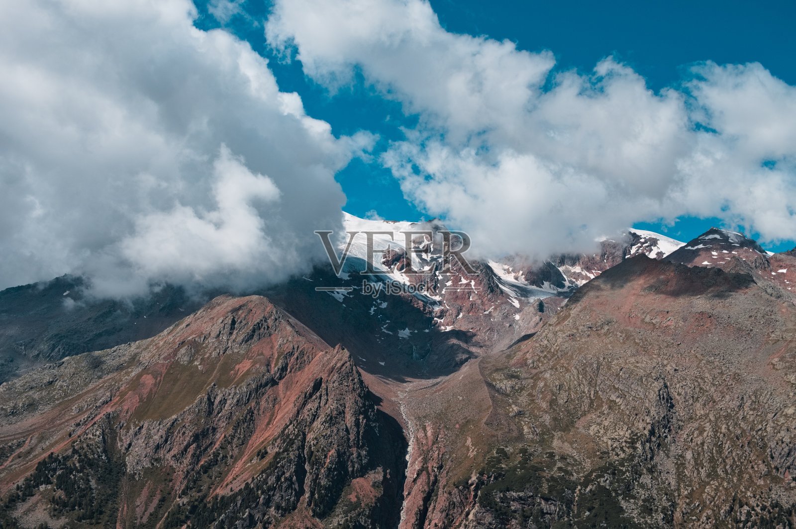 意大利阿尔卑斯山脉(Trentino，意大利，欧洲)的一座被云覆盖的雪峰。照片摄影图片