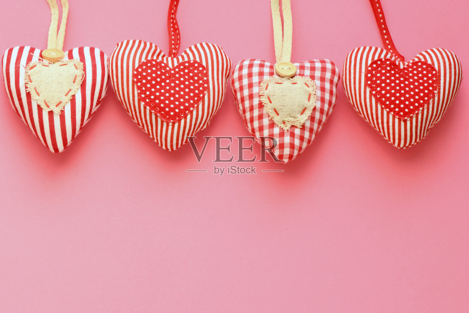 粉色背景上的心形布料。情人节，情人节。照片摄影图片