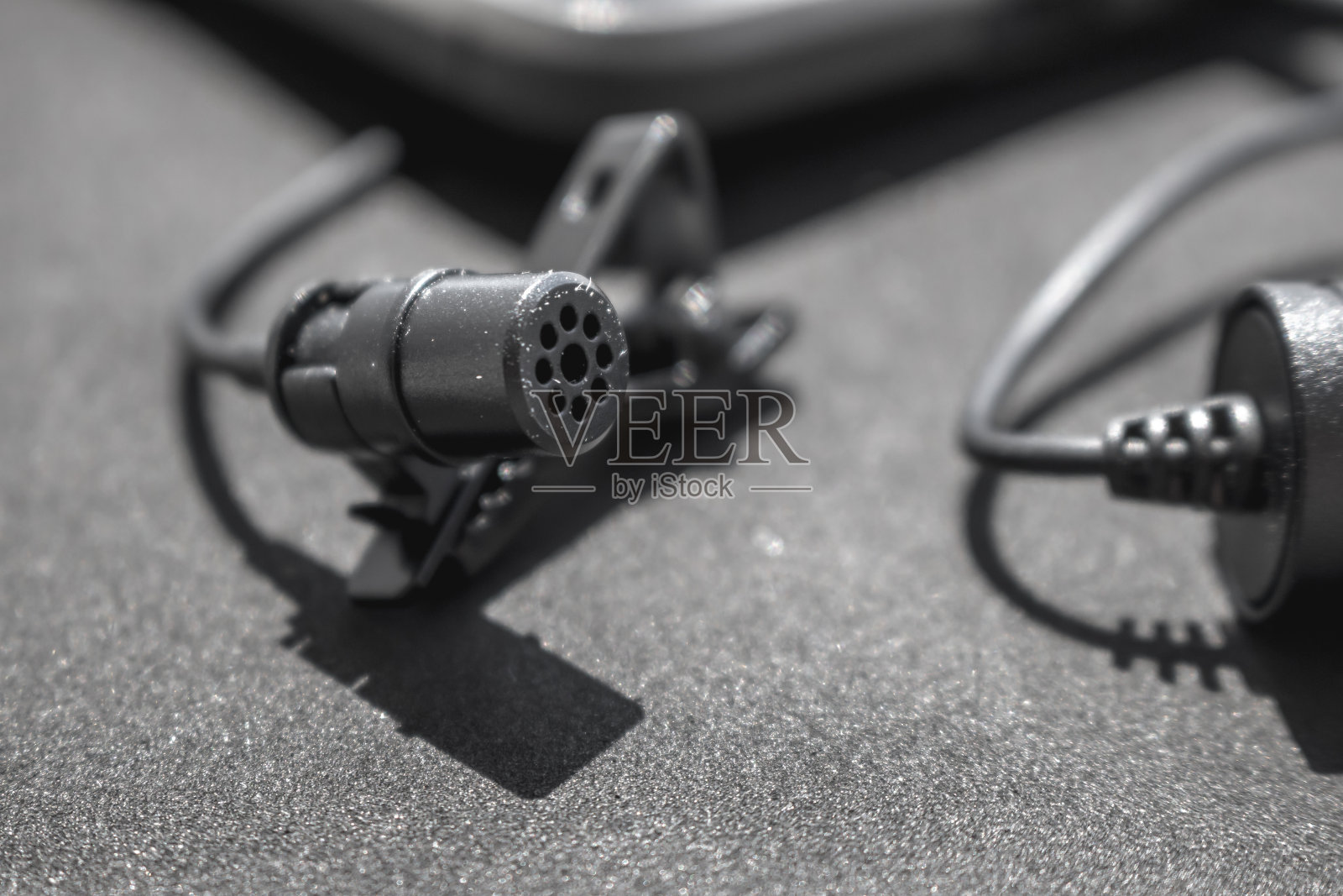 拉瓦利埃或翻领麦克风上的黑色表面。握力夹或胸罩和powerback的细节。概念有用对象，声音产生，照片摄影图片