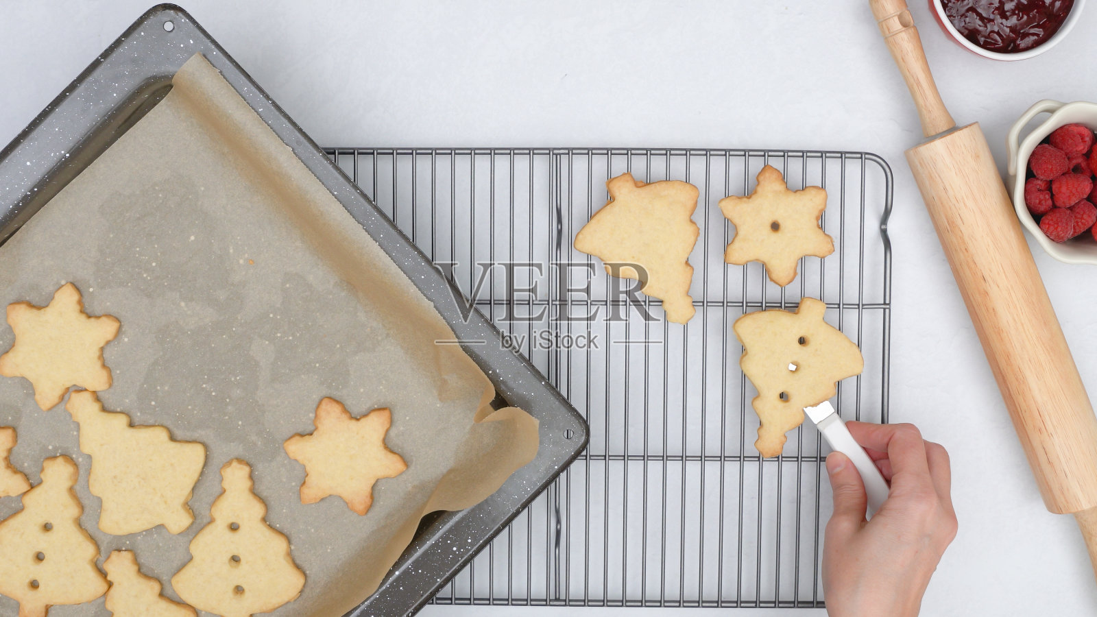 将烤好的饼干从烤盘上放到冷却架上让饼干冷却。一步一步的圣诞酥饼配覆盆子果酱食谱照片摄影图片