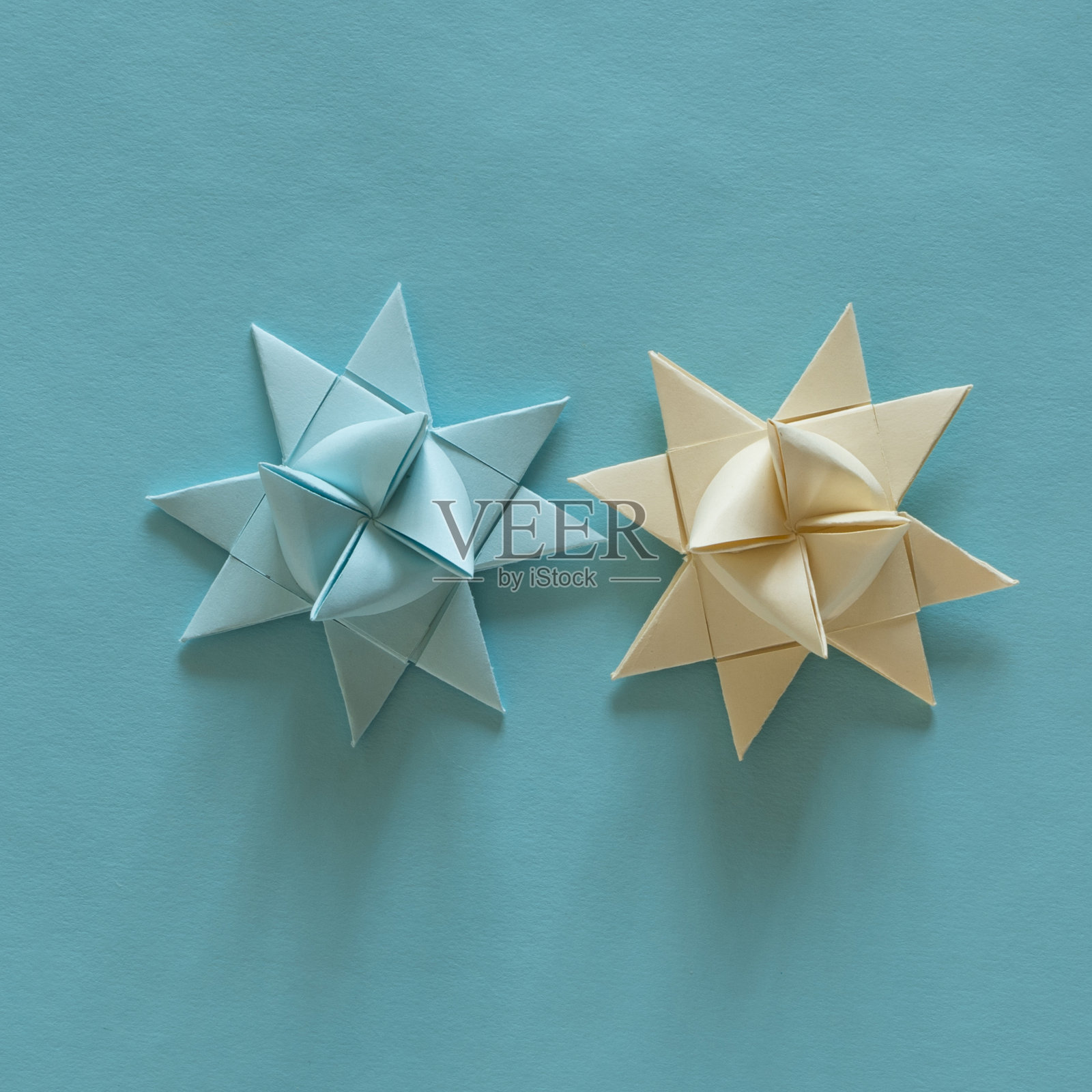 折纸3D星星，米色和浅蓝色，在浅蓝色的背景。照片摄影图片