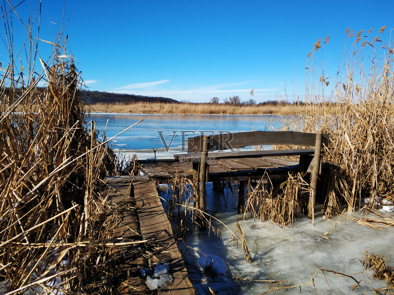 冬天的河岸。结冰的水，捕鱼的码头照片摄影图片