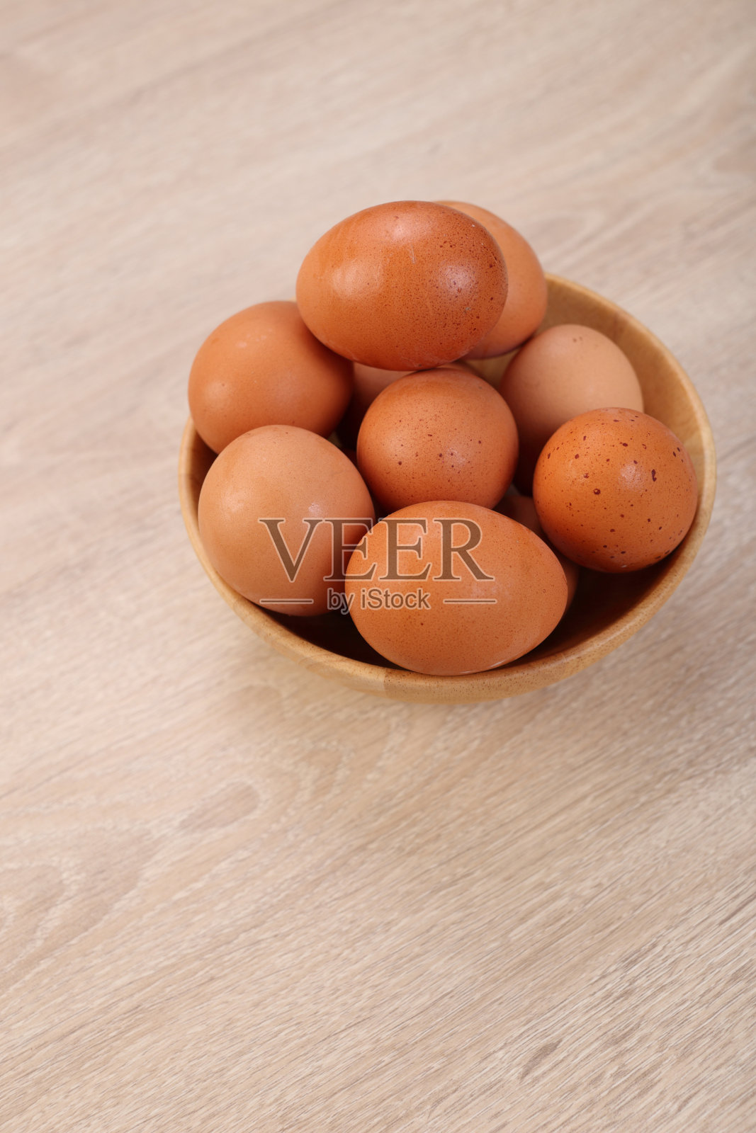 鸡蛋放在木碗里，木背景照片摄影图片
