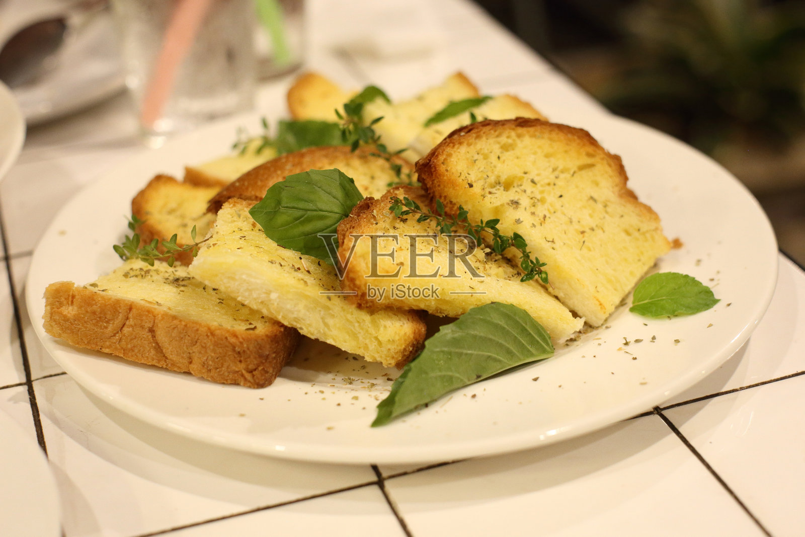 蒜蓉面包配甜罗勒白碟照片摄影图片