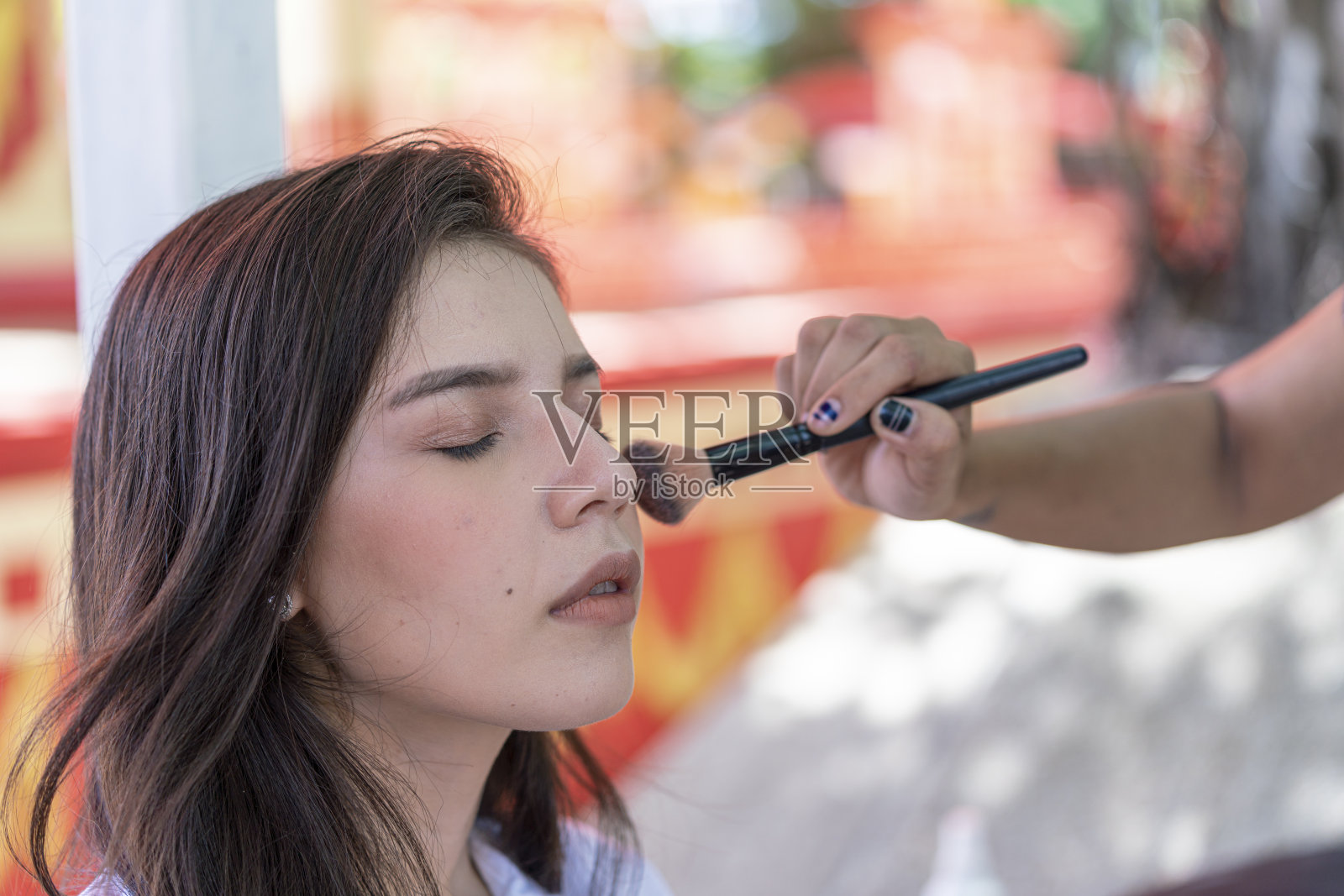 年轻漂亮的女人用化妆刷。两个朋友在咖啡馆里聚聚。照片摄影图片