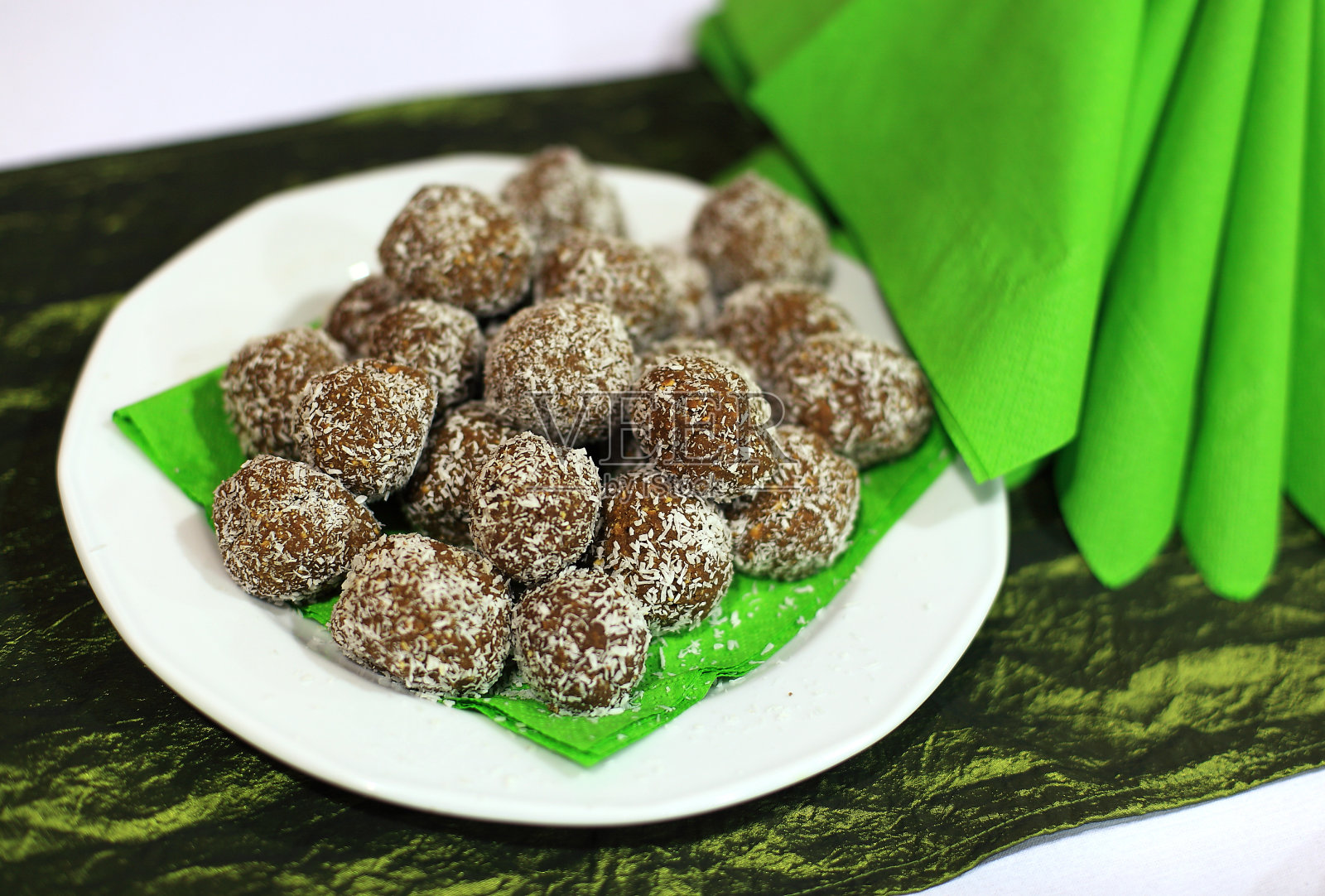 装在盘子里的可可球和绿色的餐巾照片摄影图片