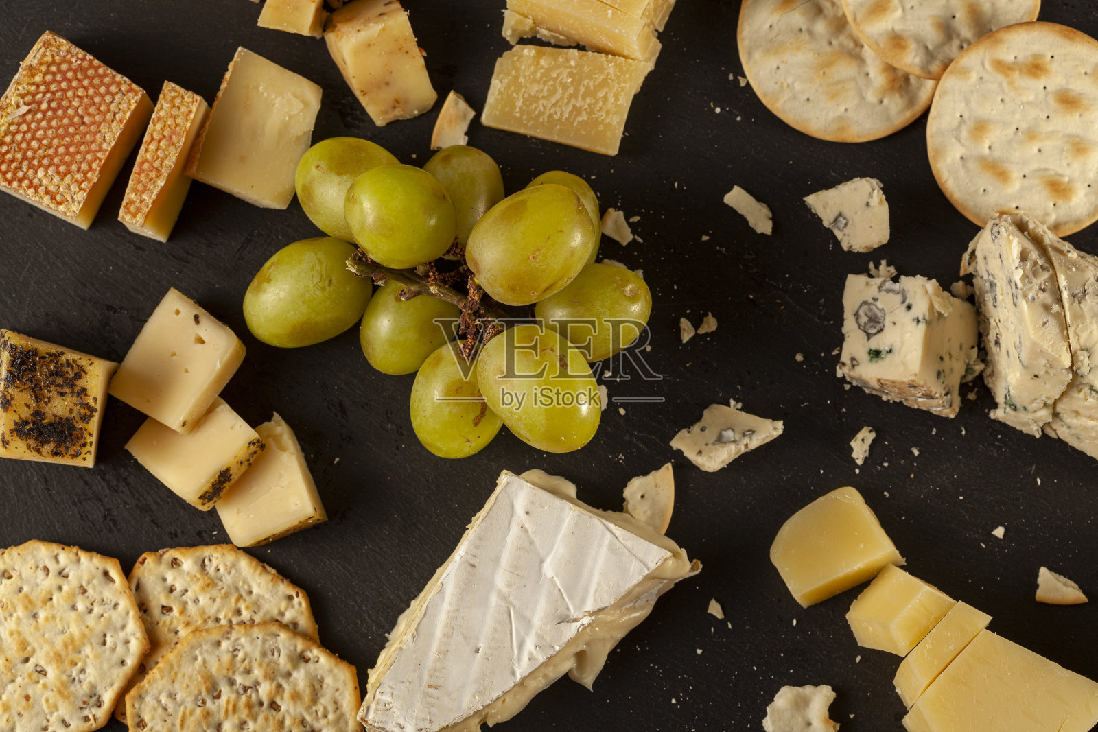 工匠奶酪拼盘与饼干和水果在黑奶酪板照片摄影图片
