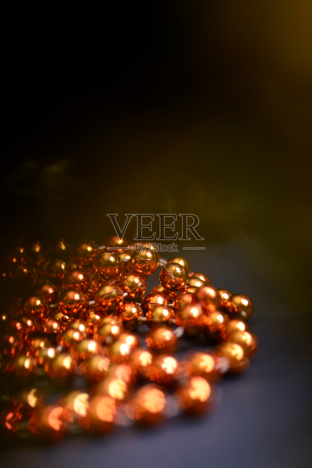 橙色的珠子和圆形的珠子装饰圣诞树，特写在一个黑暗的背景。照片摄影图片