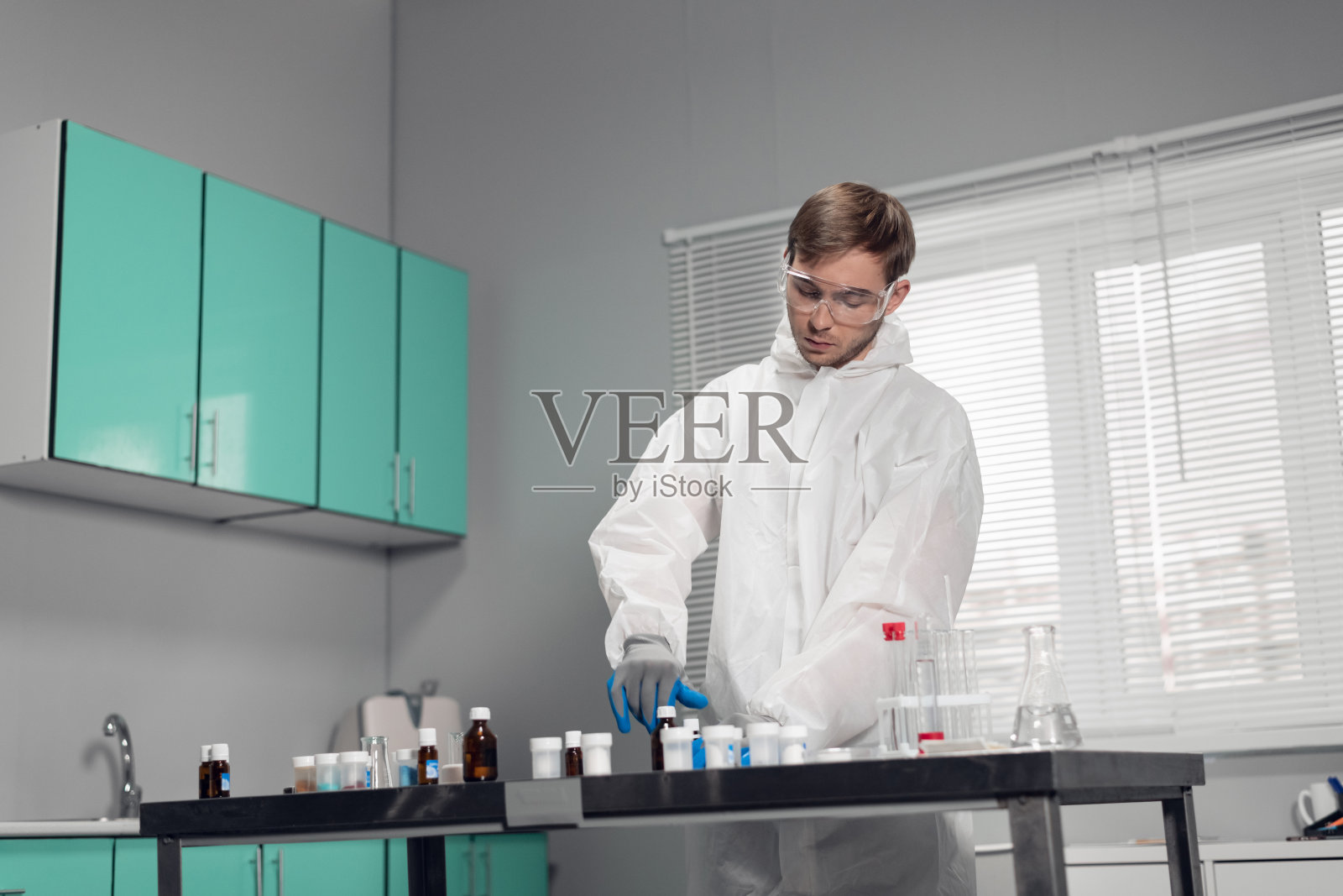 在实验室研究一种新物质的临床医生年轻英俊的化学家在实验室工作照片摄影图片