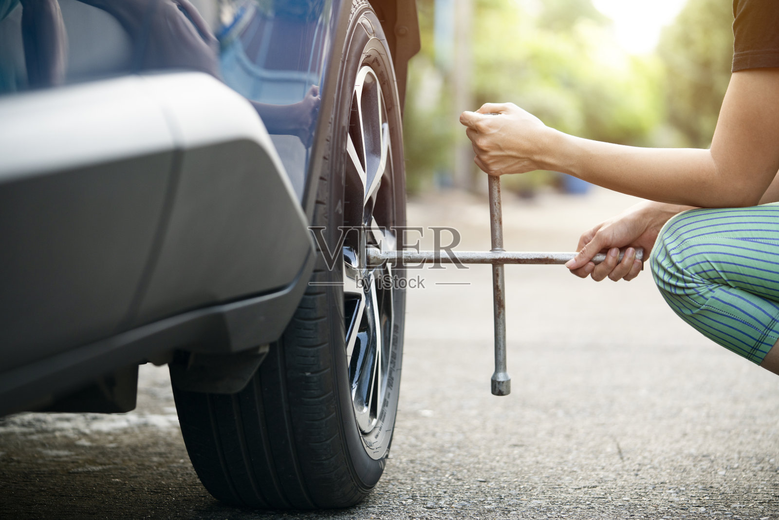女司机在路边用轮胎换轮胎照片摄影图片