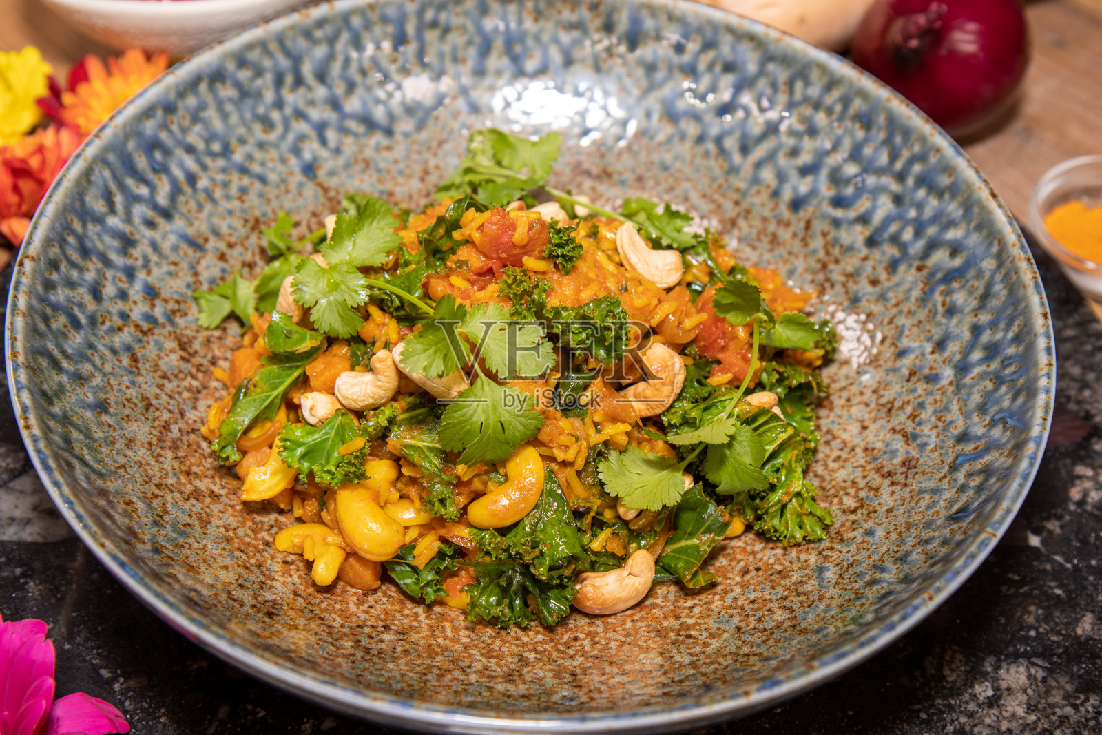 一盘配有腰果的美味冬南瓜印度饭放在厨房的木制桌子上或工作台上照片摄影图片