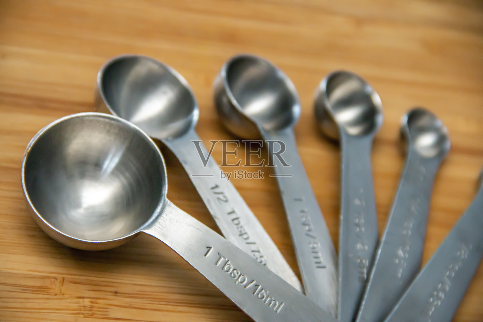 木质砧板上的银量匙照片摄影图片