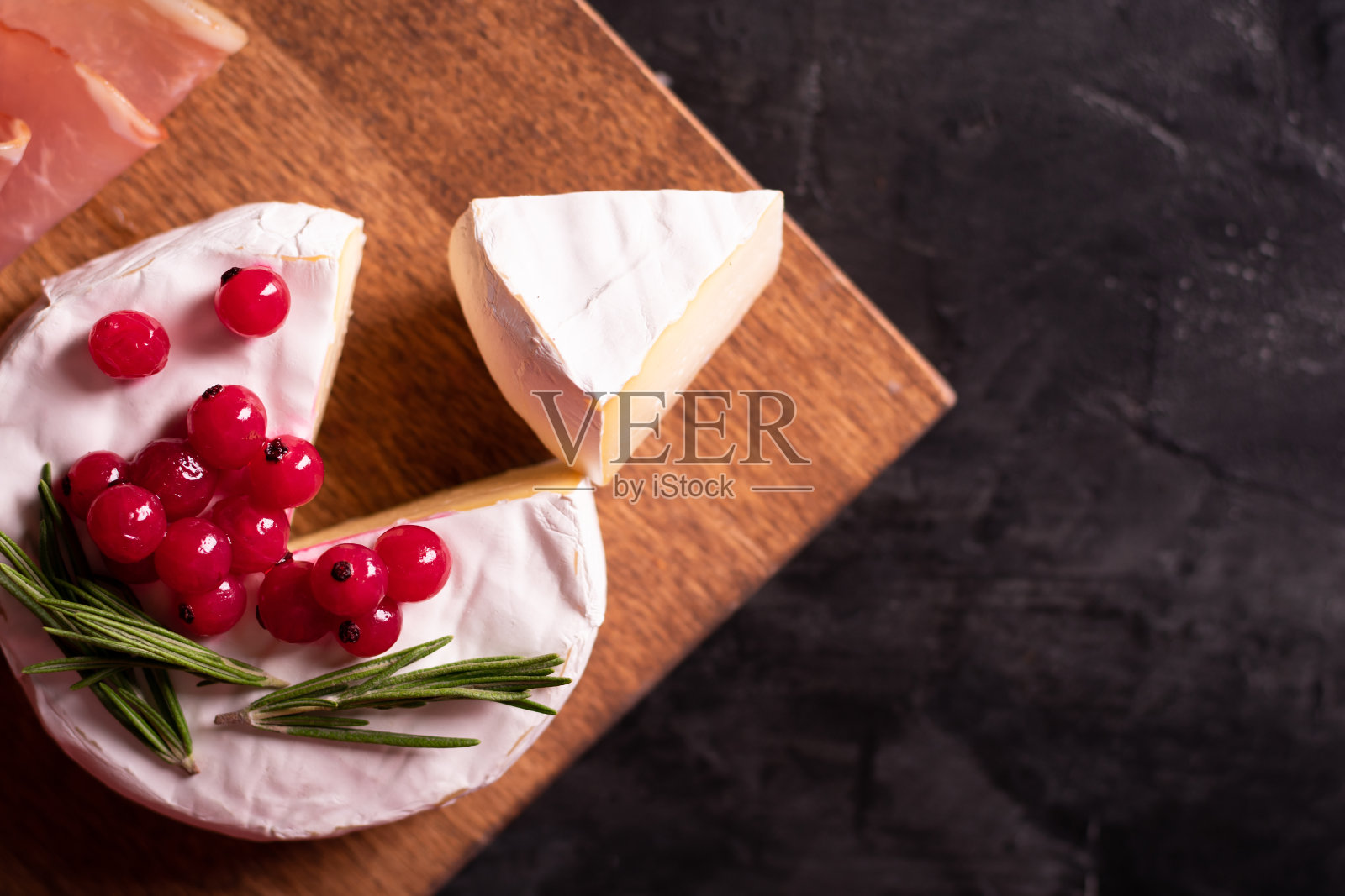 用浆果和迷迭香装饰的卡门贝尔奶酪照片摄影图片