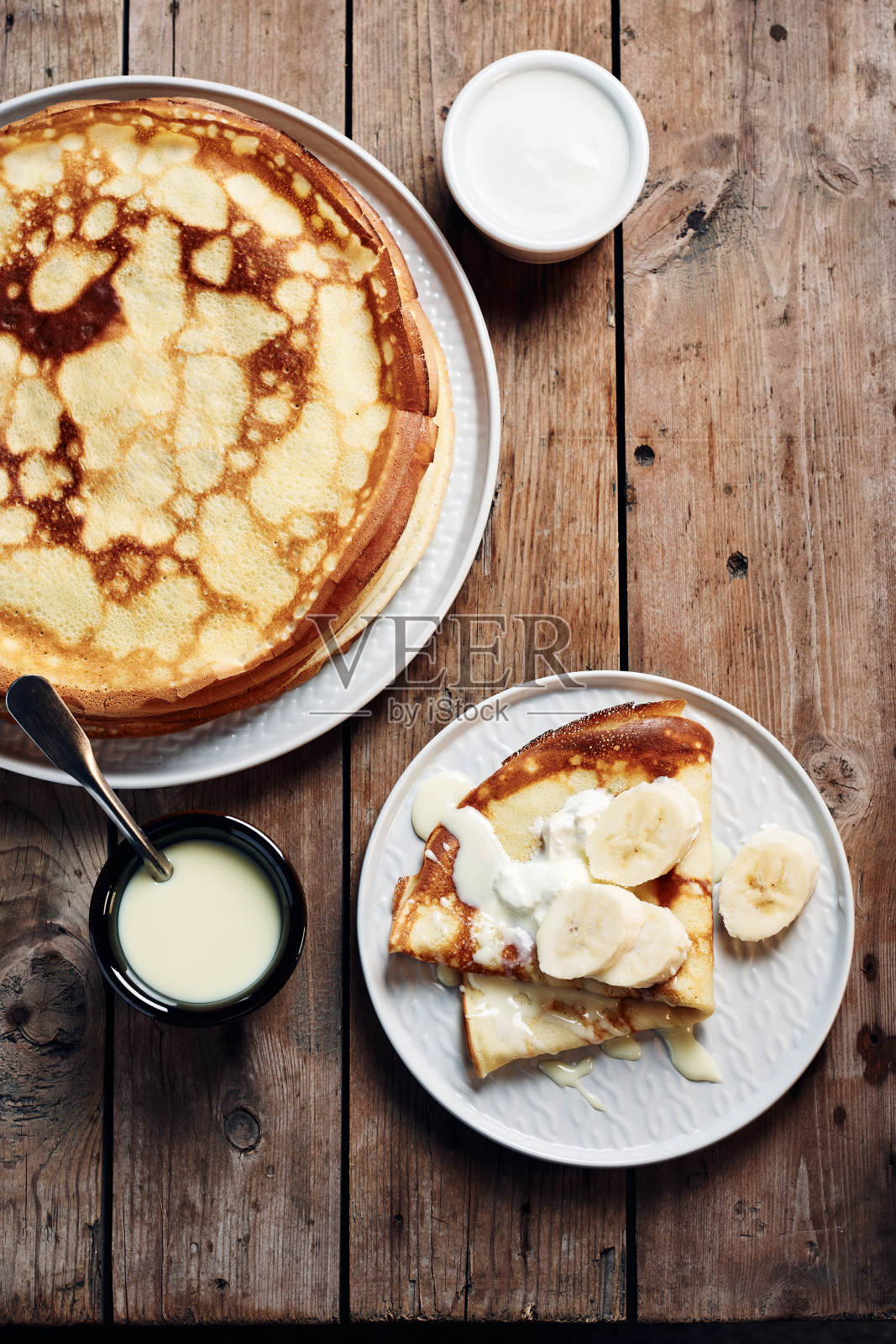 薄煎饼，香蕉薄饼和炼乳。照片摄影图片