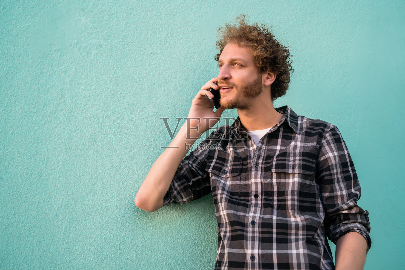 年轻人正在讲电话。照片摄影图片