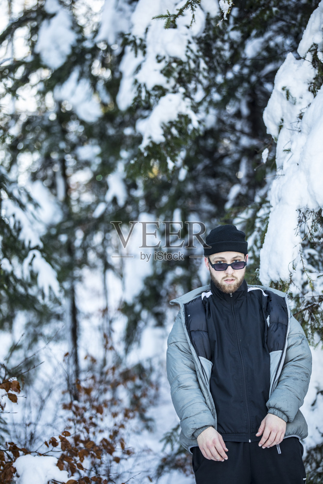 时尚的年轻成年男子与太阳镜在冬天的荒野照片摄影图片