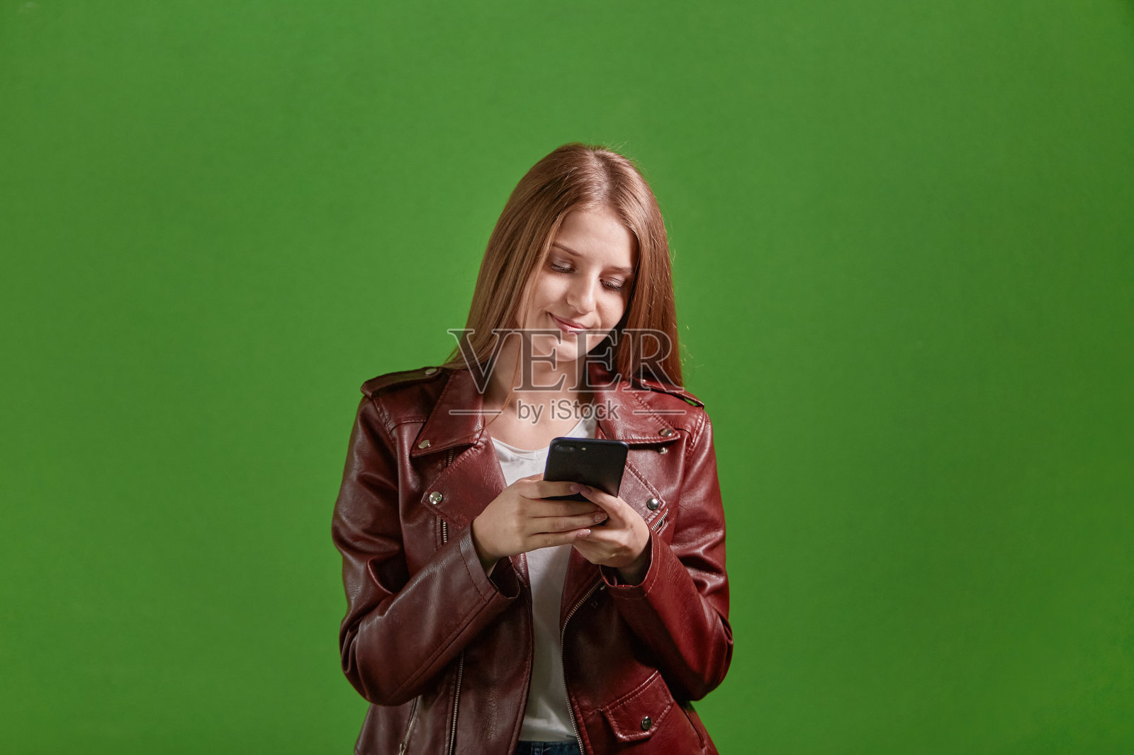 一名年轻女子手持智能手机在社交网络上交流。照片摄影图片