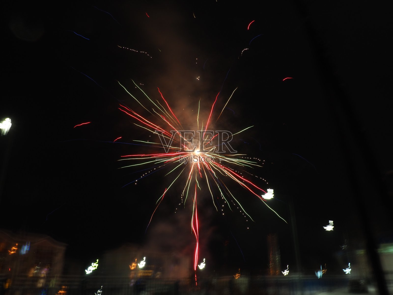 烟花在夜空中。彩色闪光的火在黑色的背景。庆典、节日或胜利的象征。爆炸的火焰和天空中的火花。飞行的彩色之字形，条纹和卷曲照片摄影图片