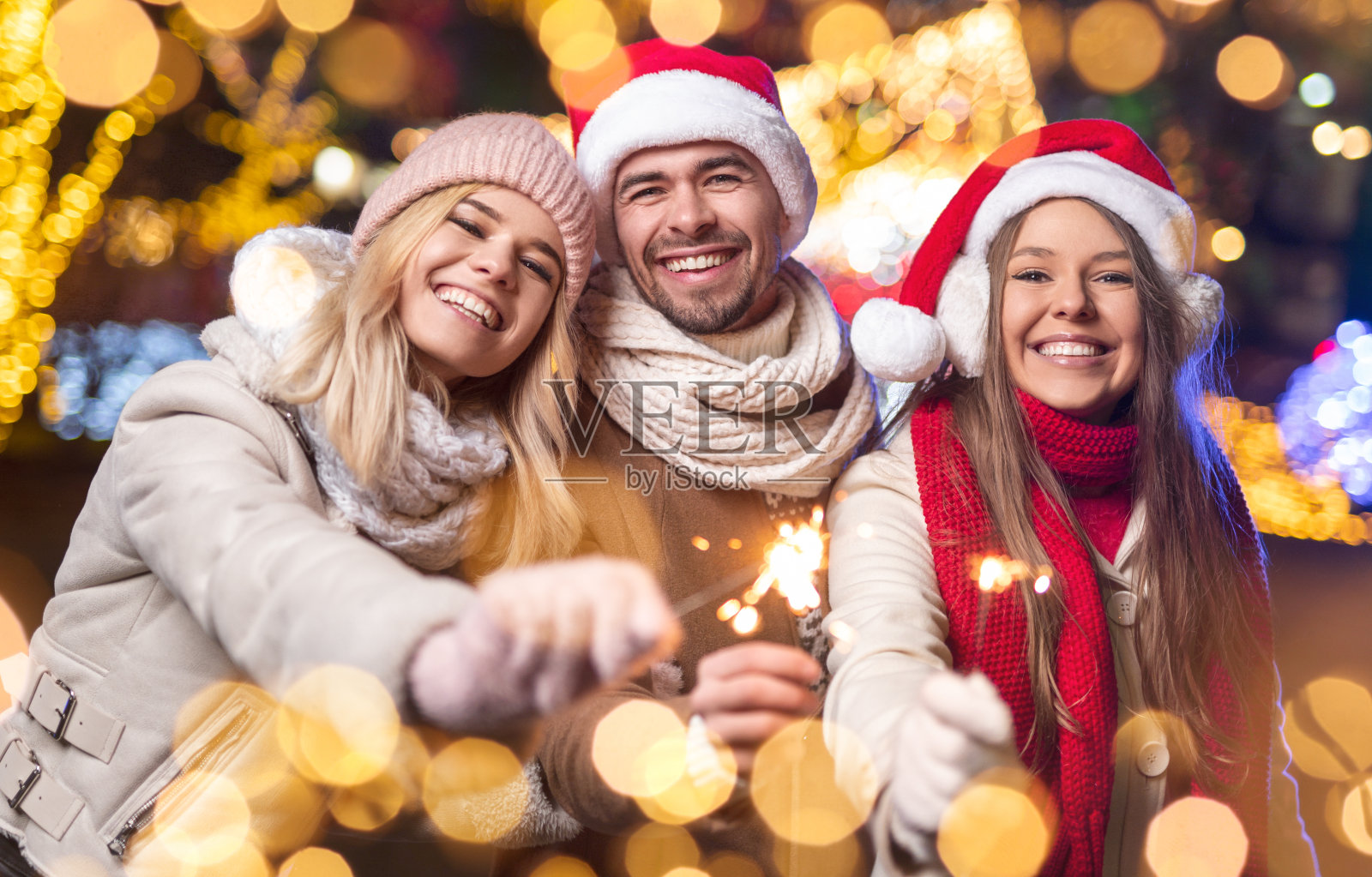 欢乐的朋友们拿着烟花一起庆祝圣诞节照片摄影图片