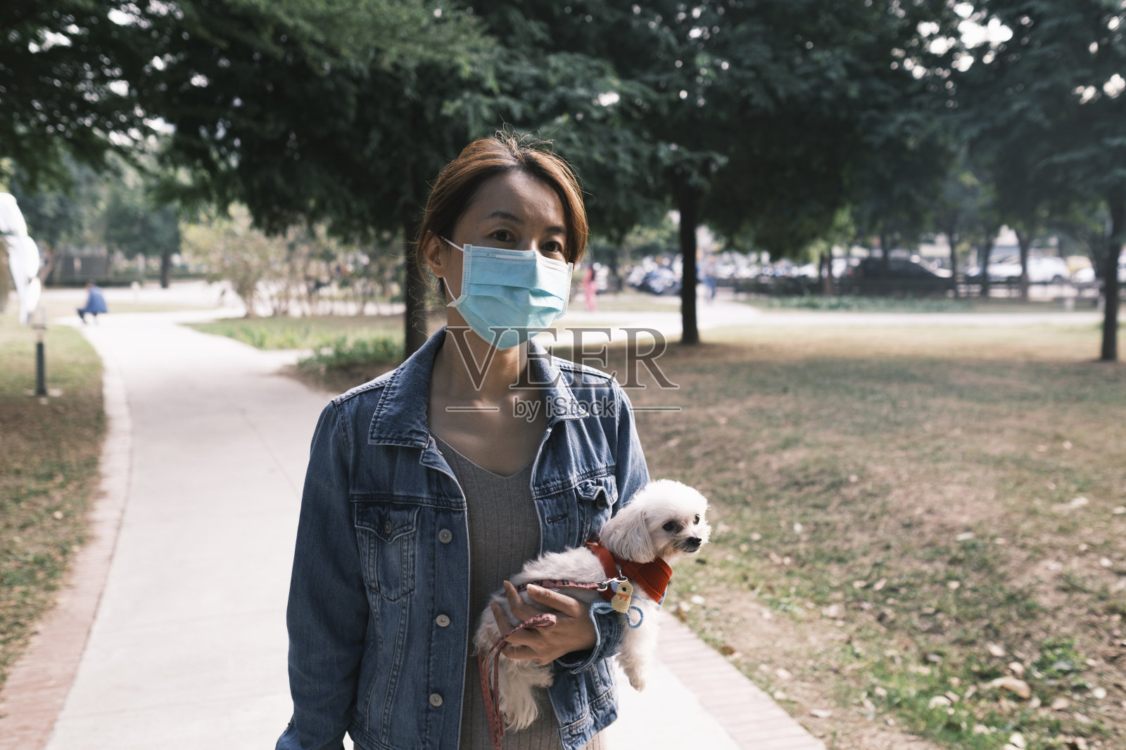 亚洲妇女在户外拥抱狗照片摄影图片