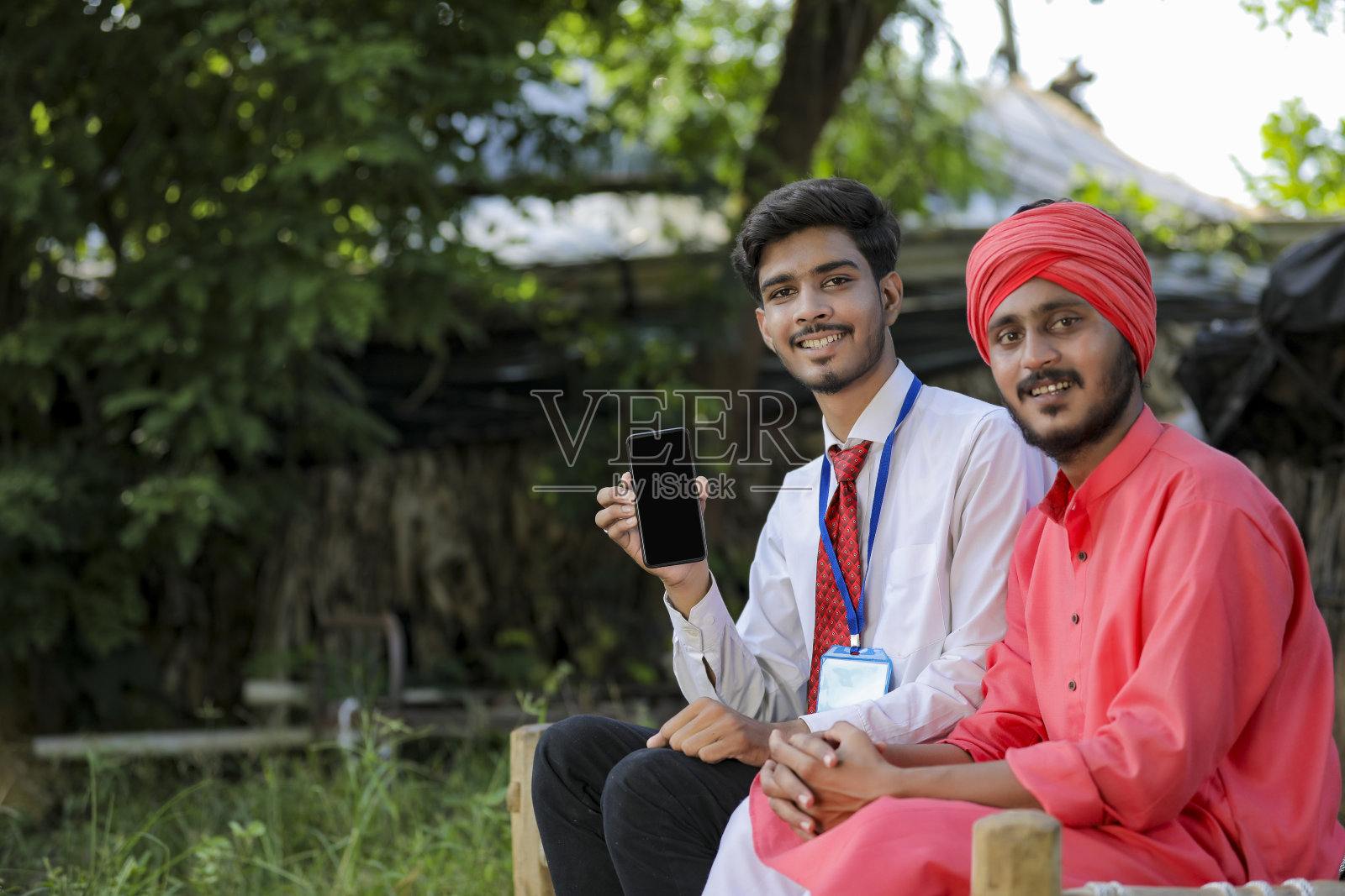 年轻的印度银行职员向农民展示手机屏幕照片摄影图片