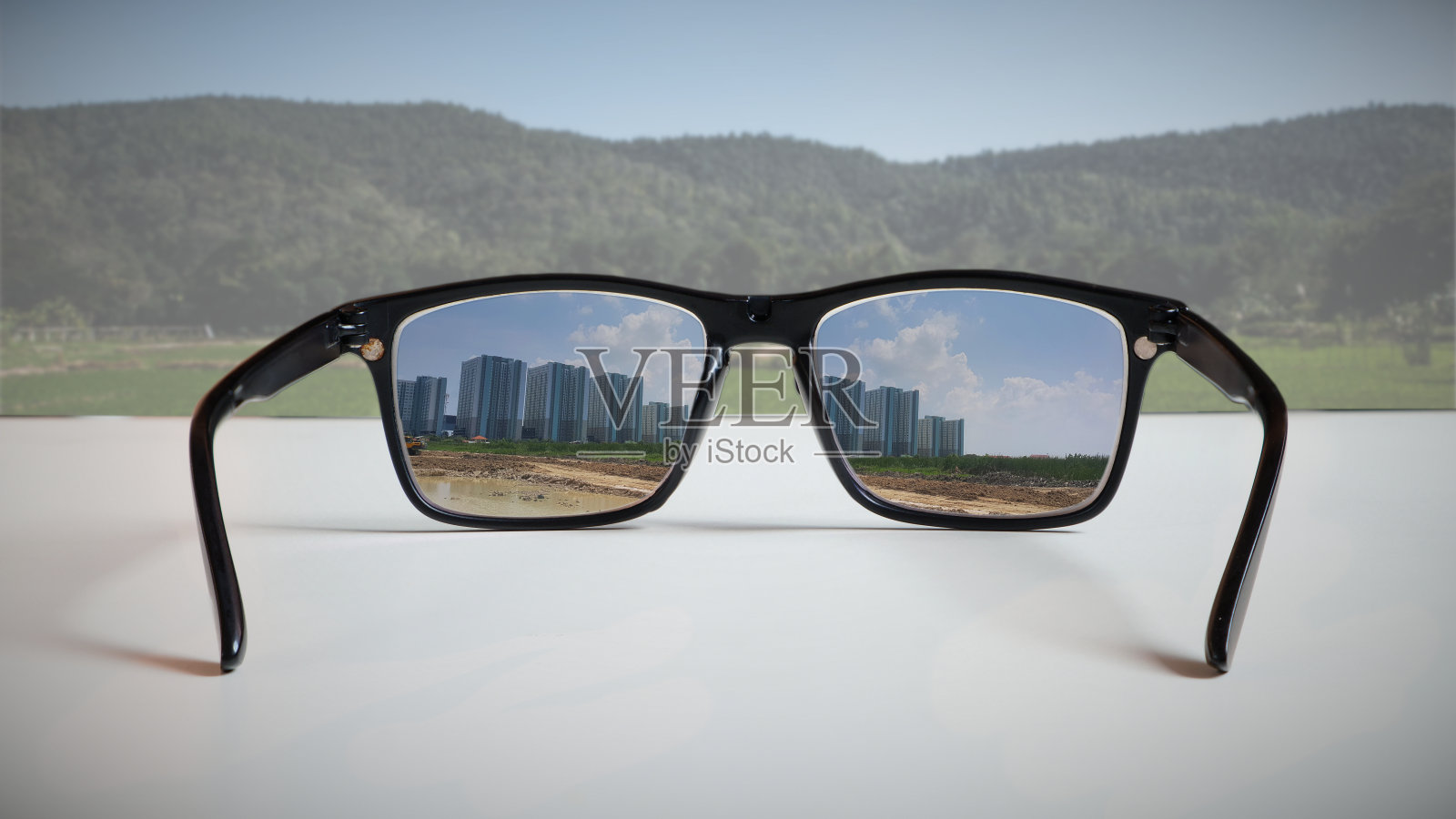 抽象的照片反映了一个房地产开发商的愿景。通过镜片反射高层建筑的图像，看到一个未开发的地区。照片摄影图片