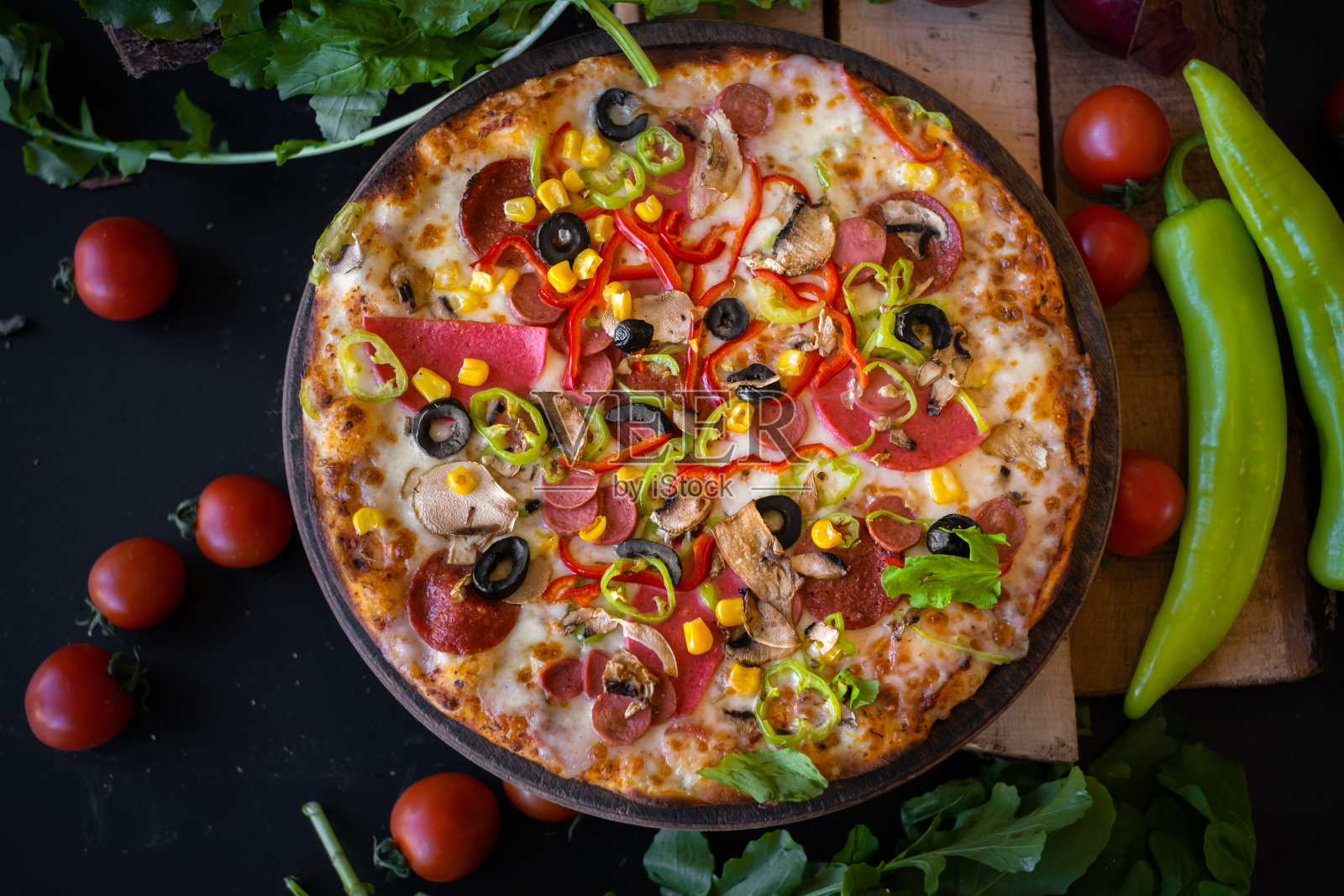 混合披萨青椒西红柿和芝麻菜在黑色的背景照片摄影图片