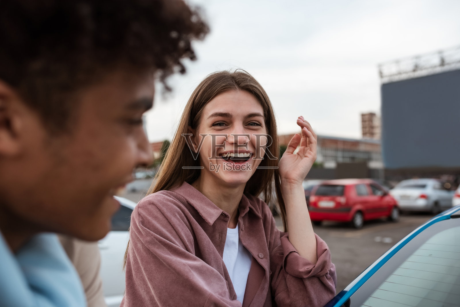 年轻的白人女孩和非裔美国人在汽车影院约会照片摄影图片
