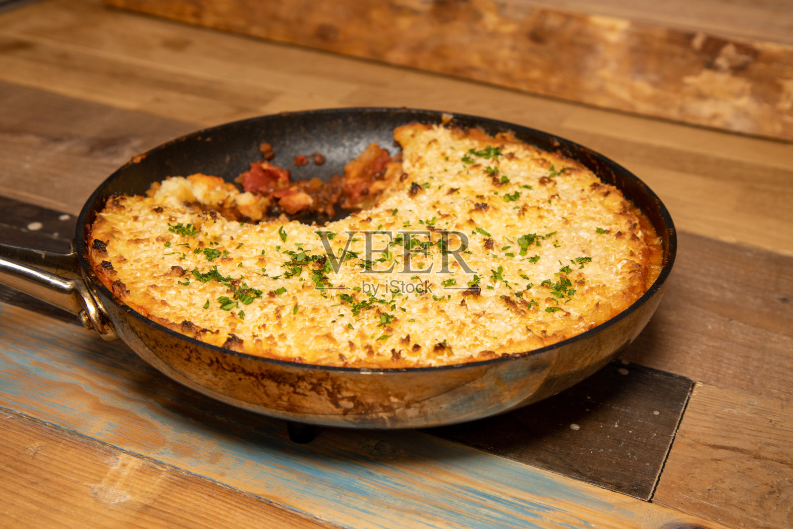 一顿美味的防风草牧羊人派在平底锅里放在厨房的木制工作台上照片摄影图片