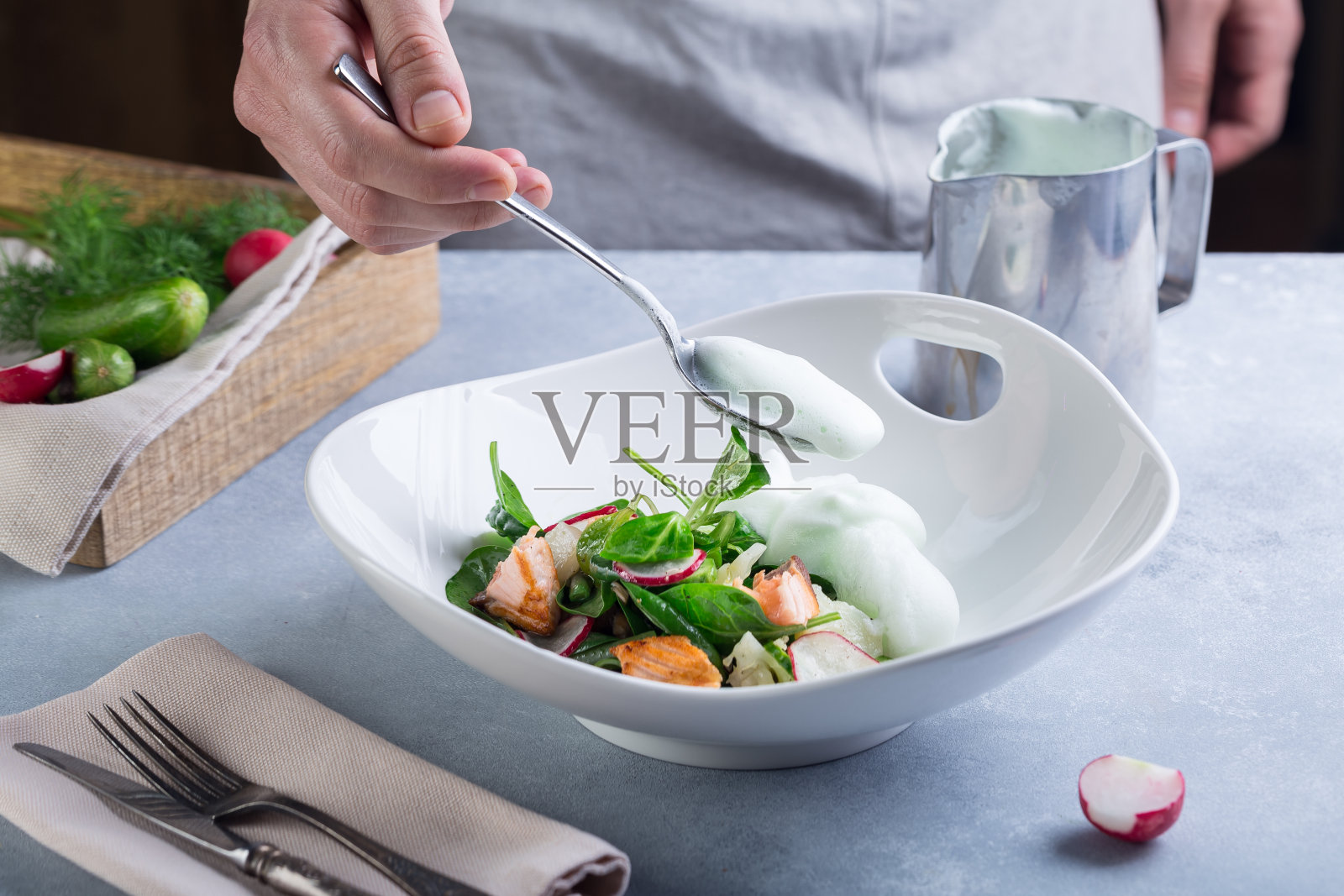 厨师完成烹饪沙拉，并加入白酱到红鱼和蔬菜照片摄影图片