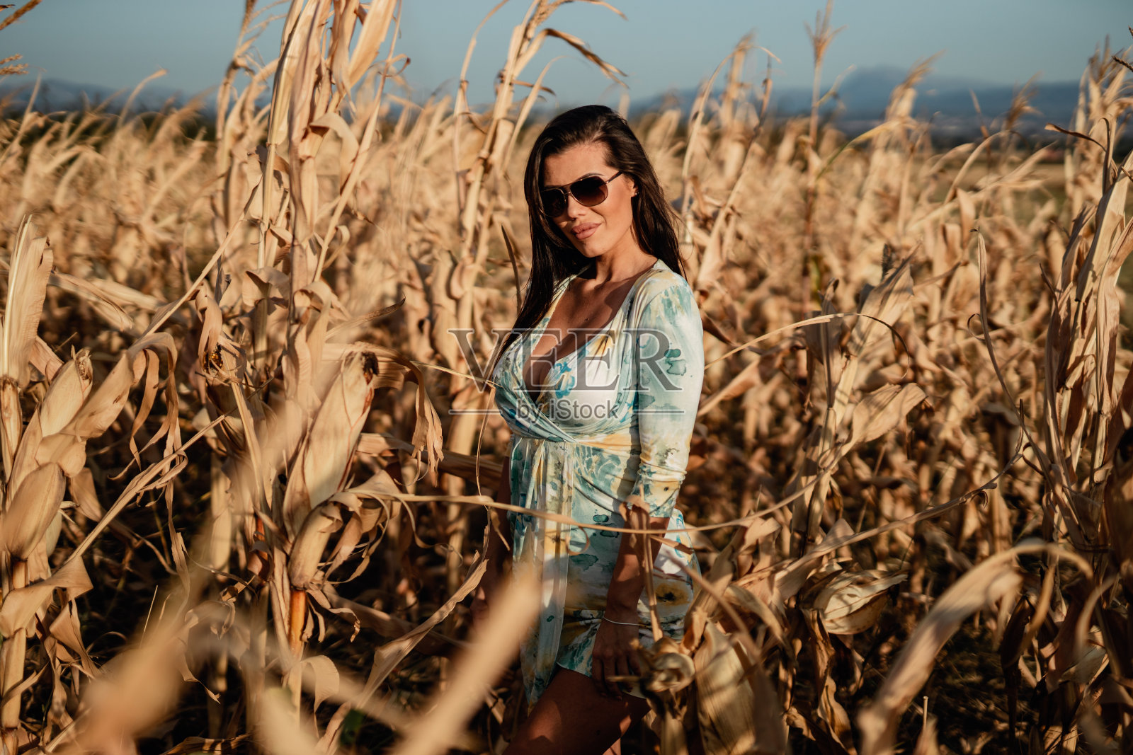 在一个阳光明媚的日子里，一个穿着夏装的女人在大自然中照片摄影图片