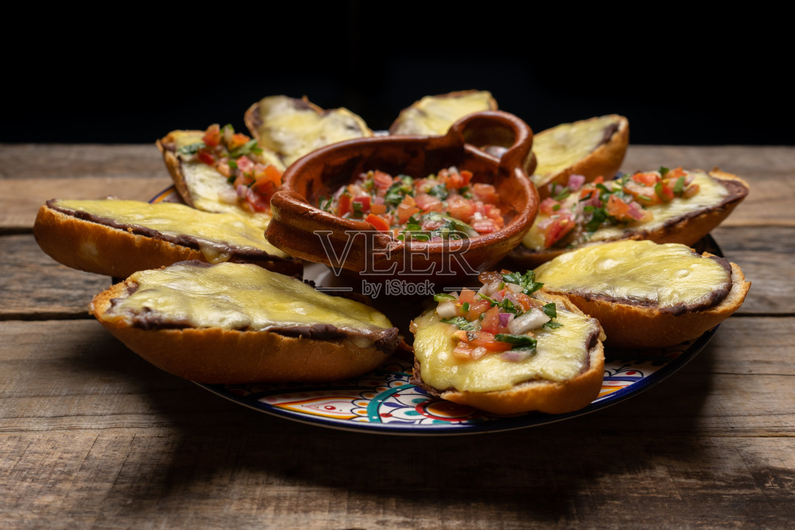 墨西哥煎丸子，配上新鲜的奶酪和酱汁，背景是木头照片摄影图片