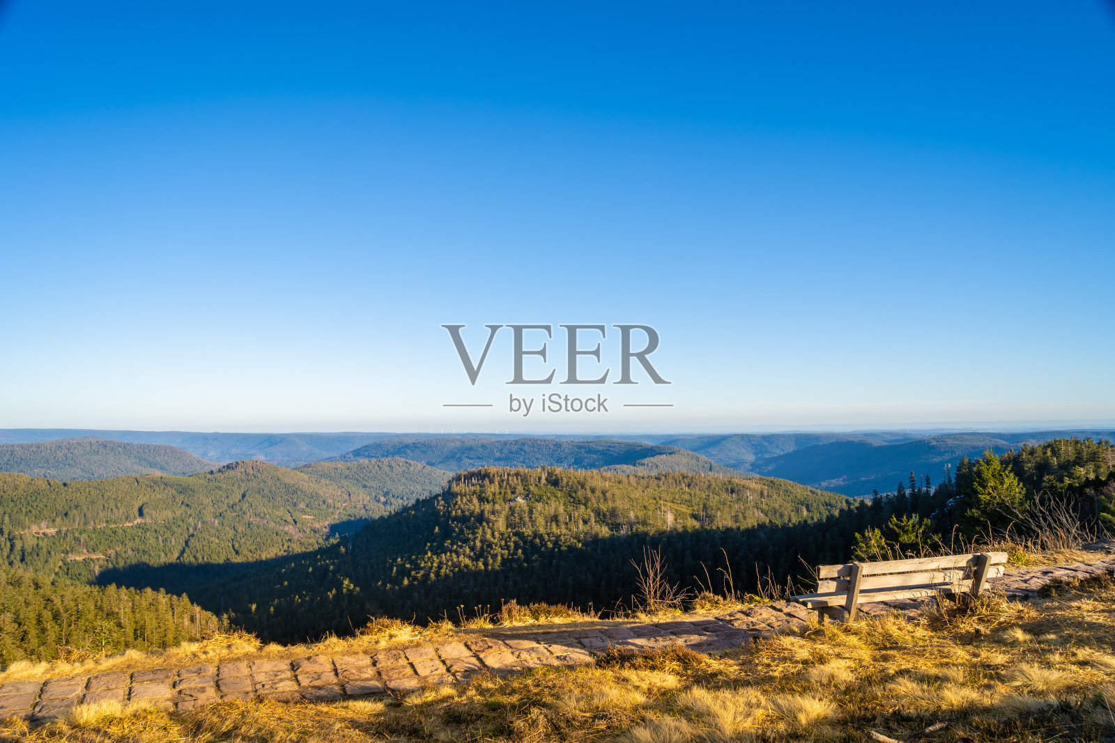 阳光下的山顶长凳，遥望远方照片摄影图片