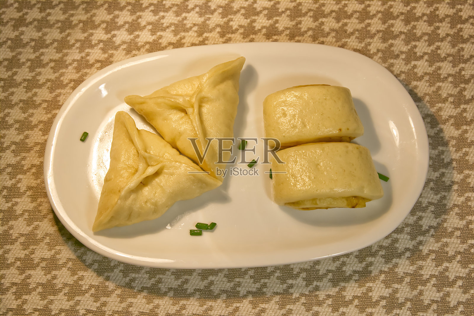 馒头和三角包放在盘子里，俯视，自制美食照片摄影图片