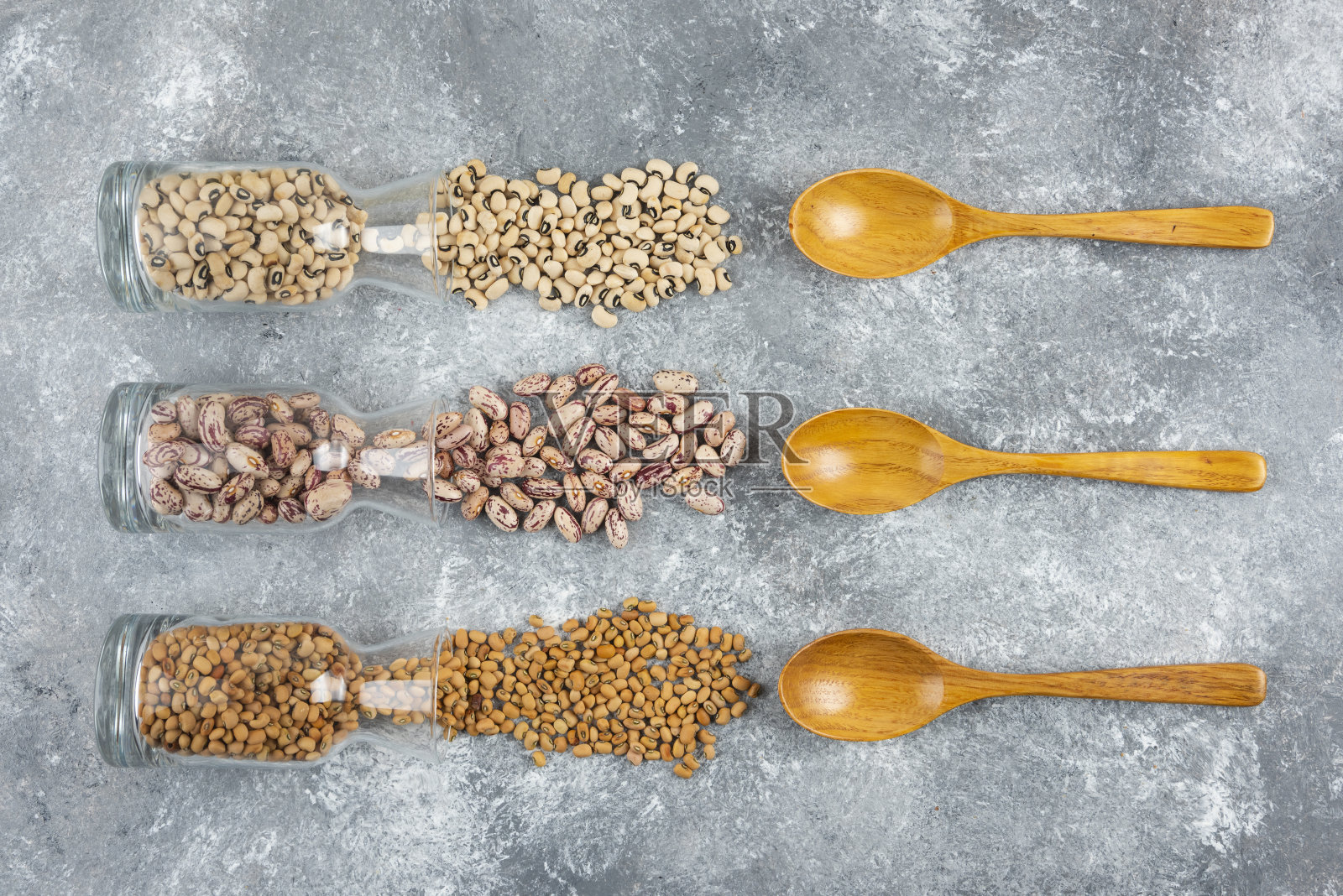 灰色背景上放着三杯混合生豆子的罐子照片摄影图片