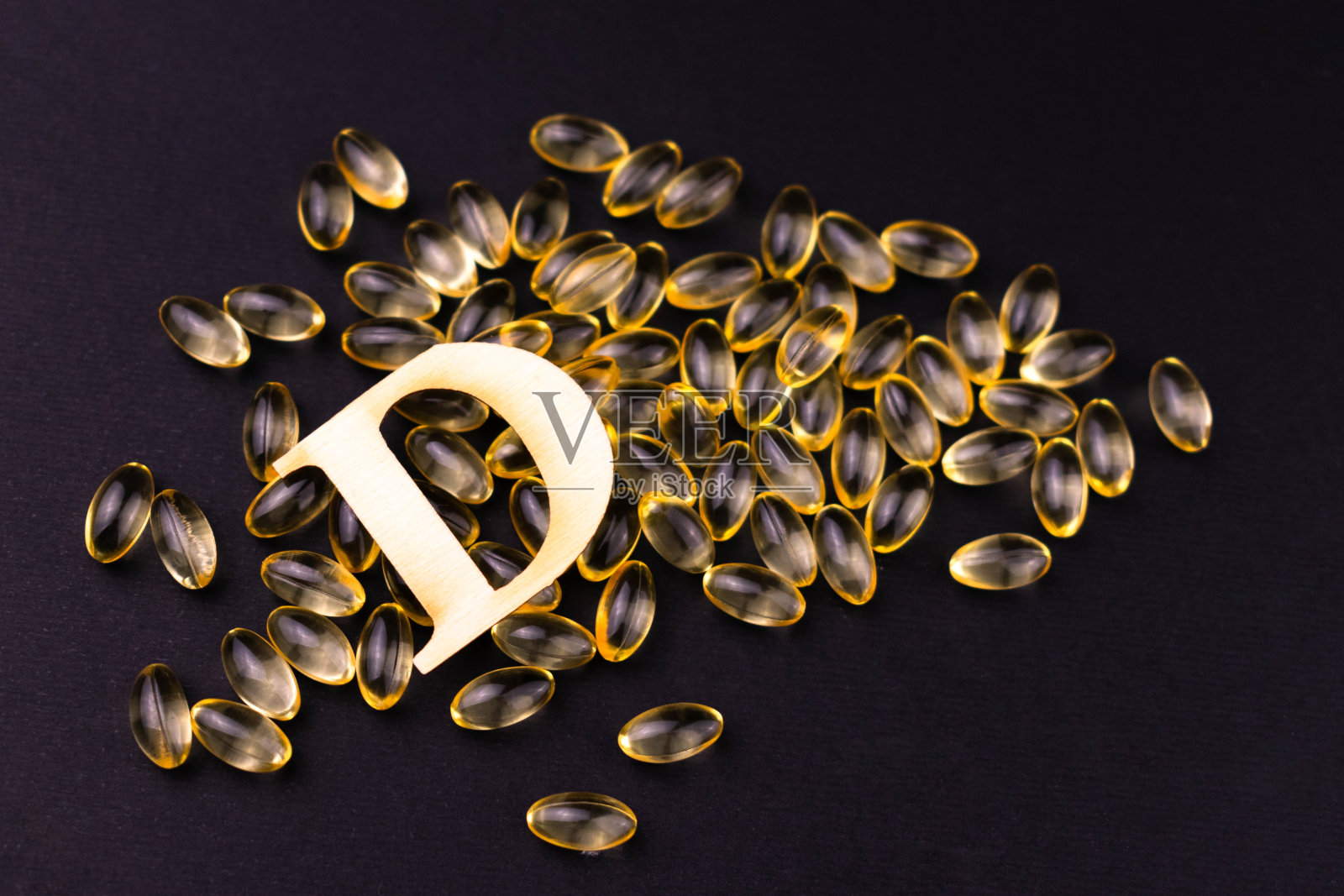 黑色背景上的维生素D胶囊。前视图。照片摄影图片