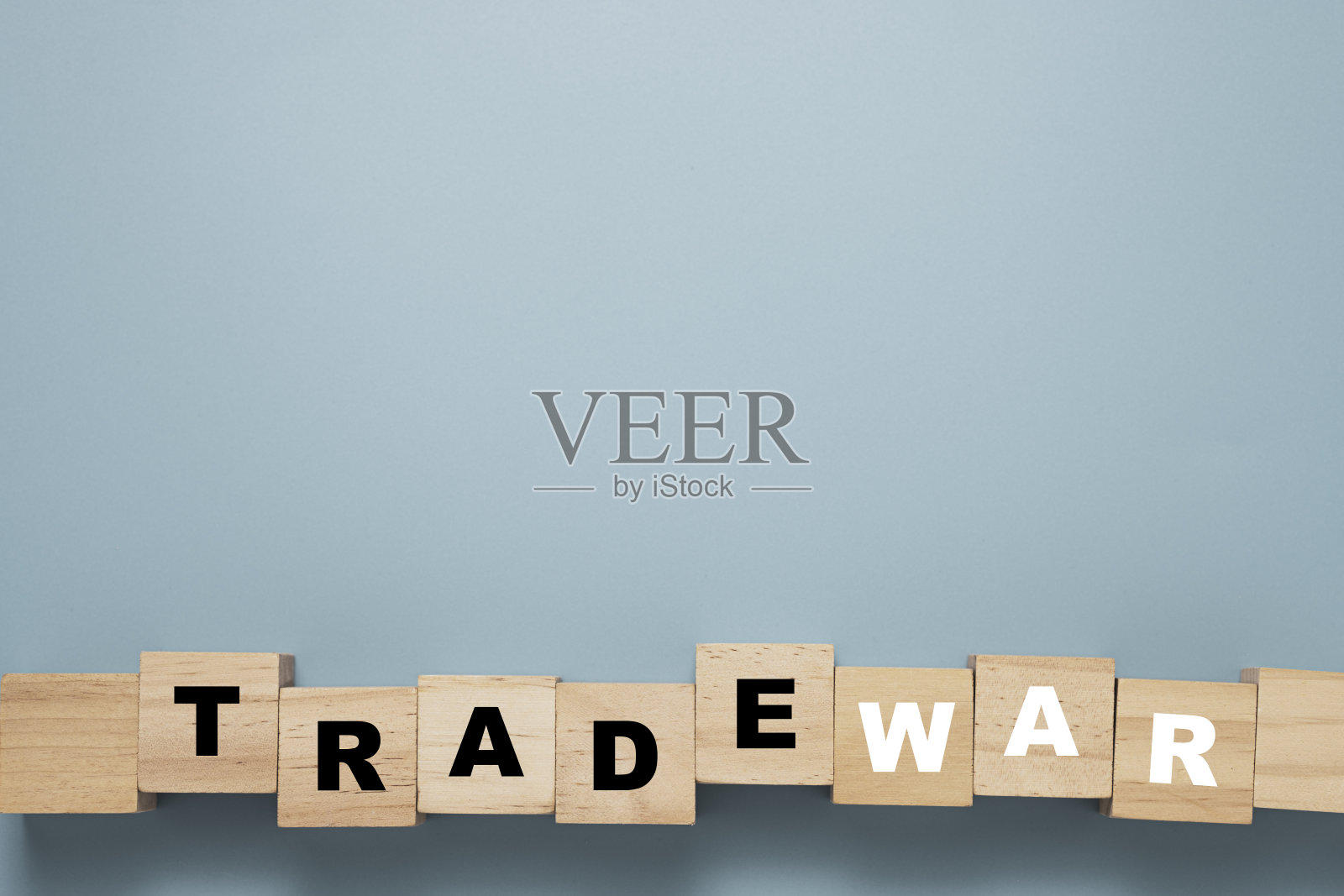贸易战词打印屏幕上的木块立方体与蓝色背景。照片摄影图片