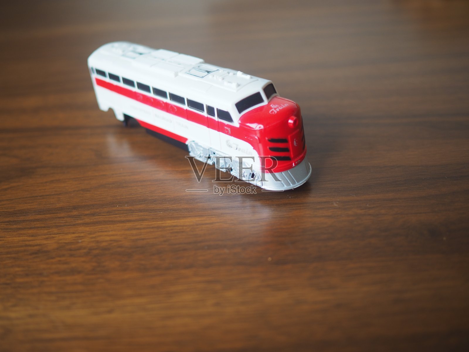 红色和白色的玩具火车在木桌上照片摄影图片