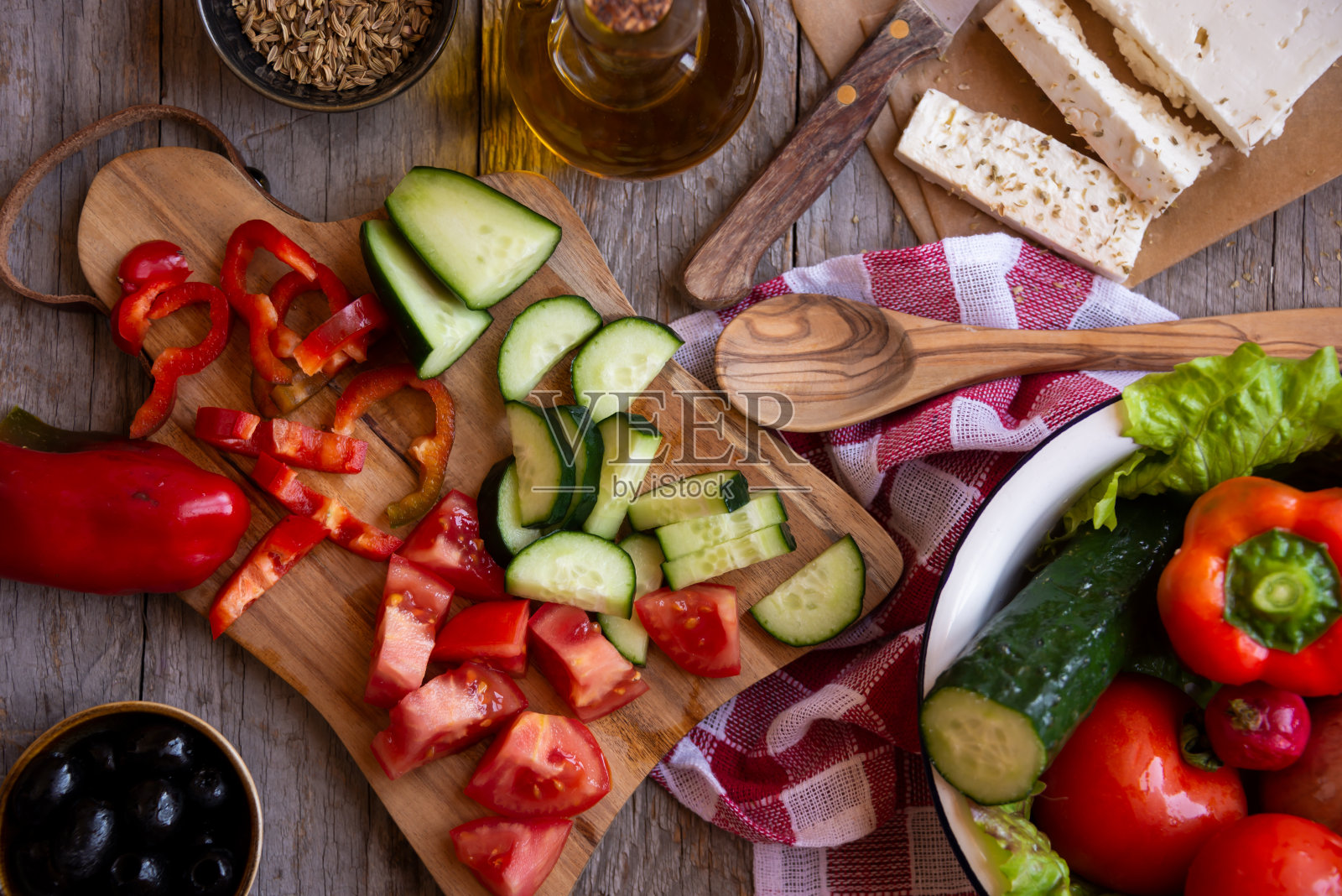 蔬菜沙拉的配料:西红柿，黄瓜，羊乳酪，切好的蔬菜。准备希腊沙拉照片摄影图片