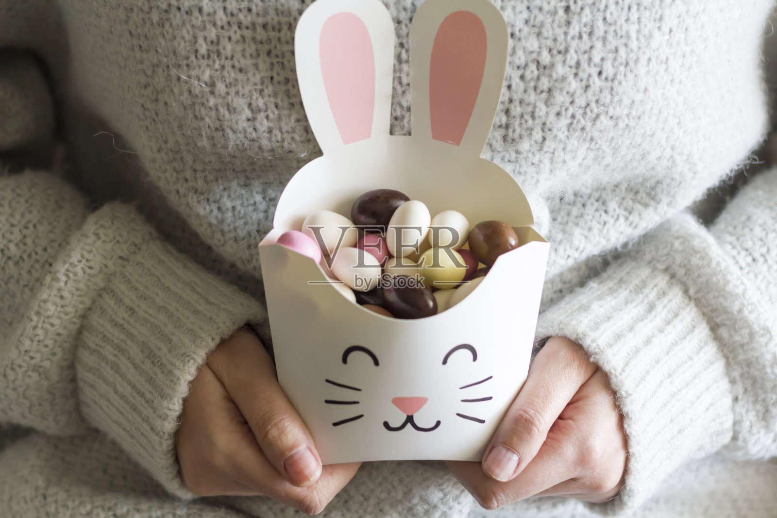 女人手拿着兔子盒子，里面有复活节甜蛋照片摄影图片