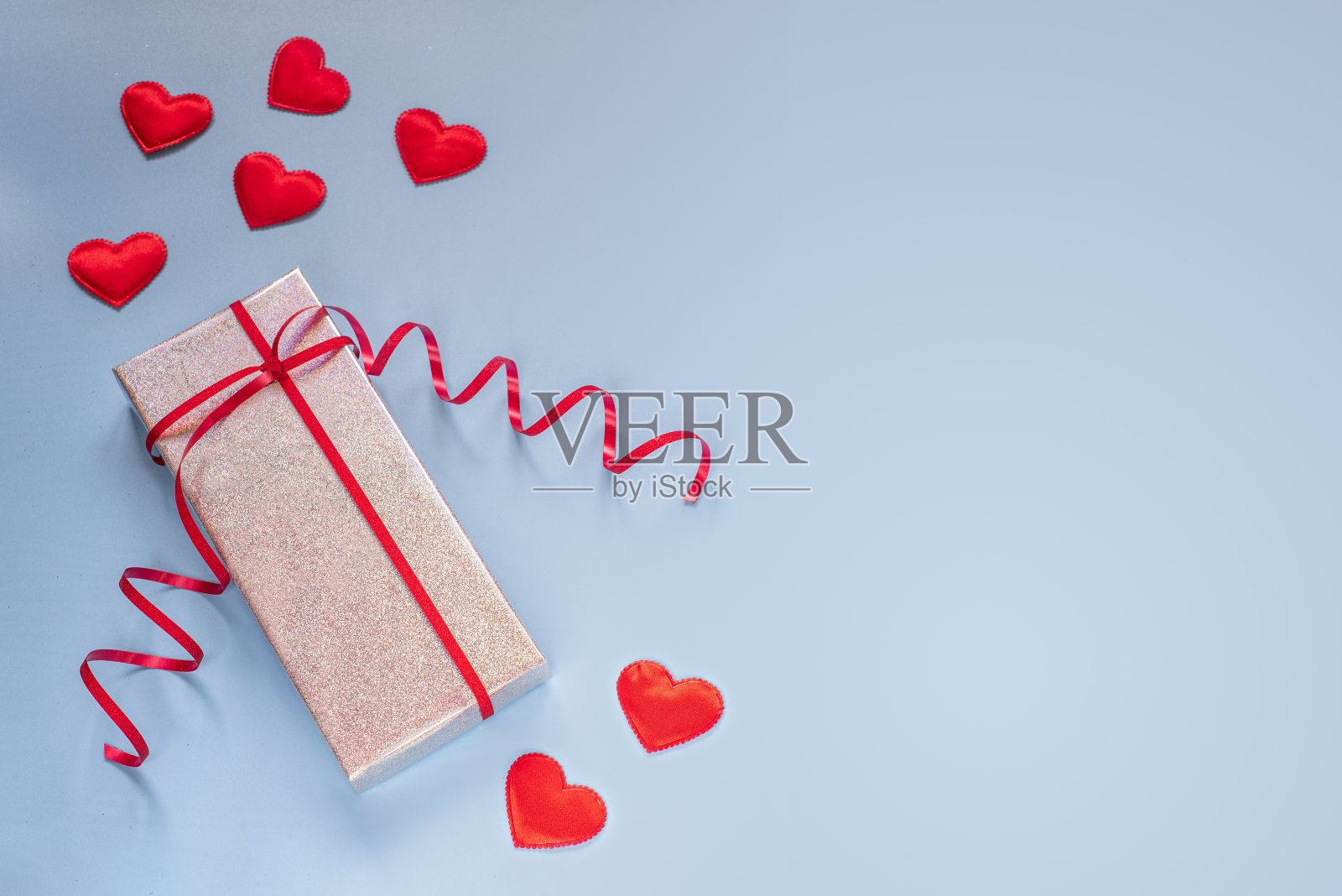 情人节蓝色背景上的礼品盒和红色爱心创意布局照片摄影图片