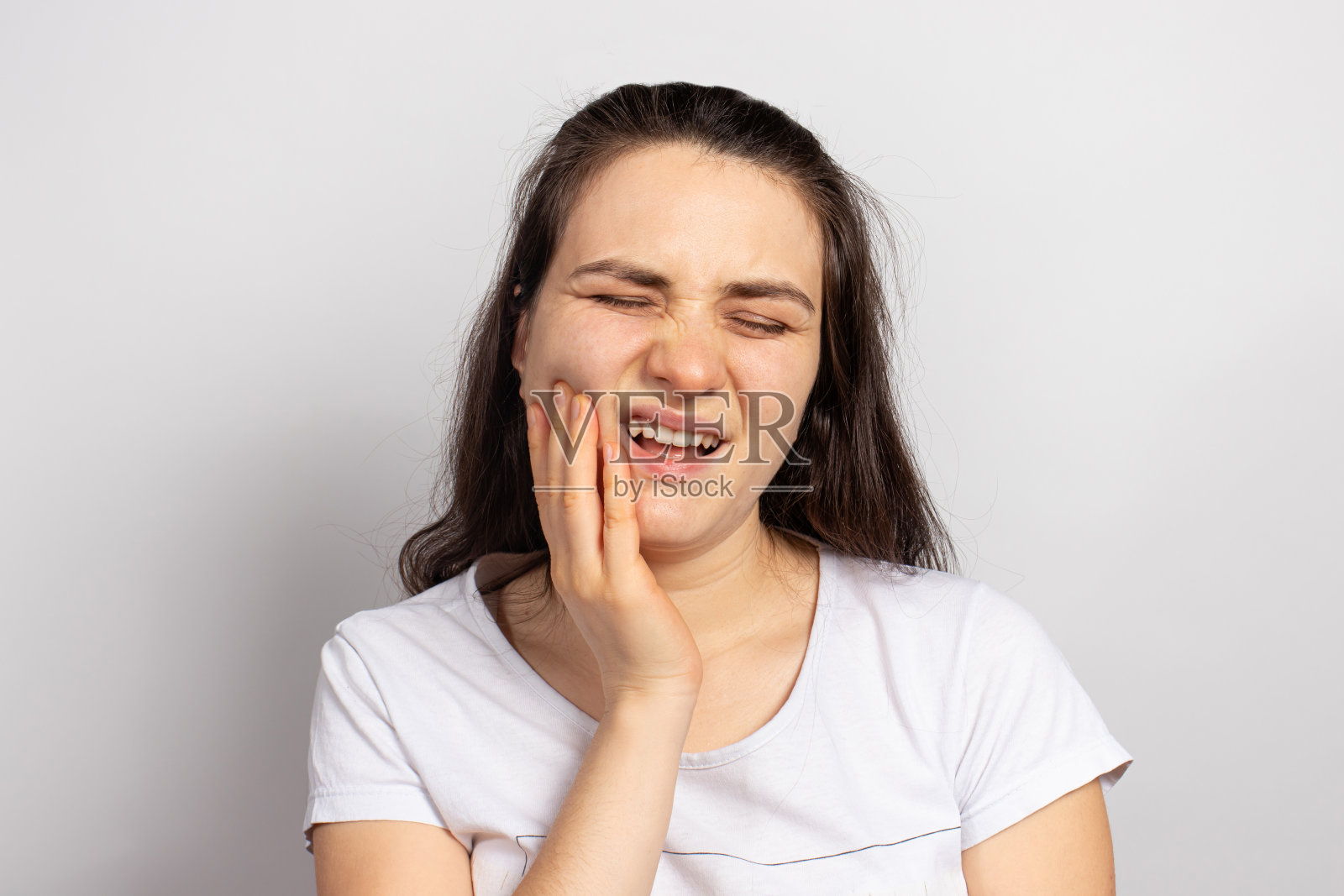 这名妇女患有牙痛——龋齿或牙髓炎、炎症、填充物脱落或坏掉的牙齿吃了硬坚果。牙痛，牙科诊所和牙医照片。口腔护理照片摄影图片