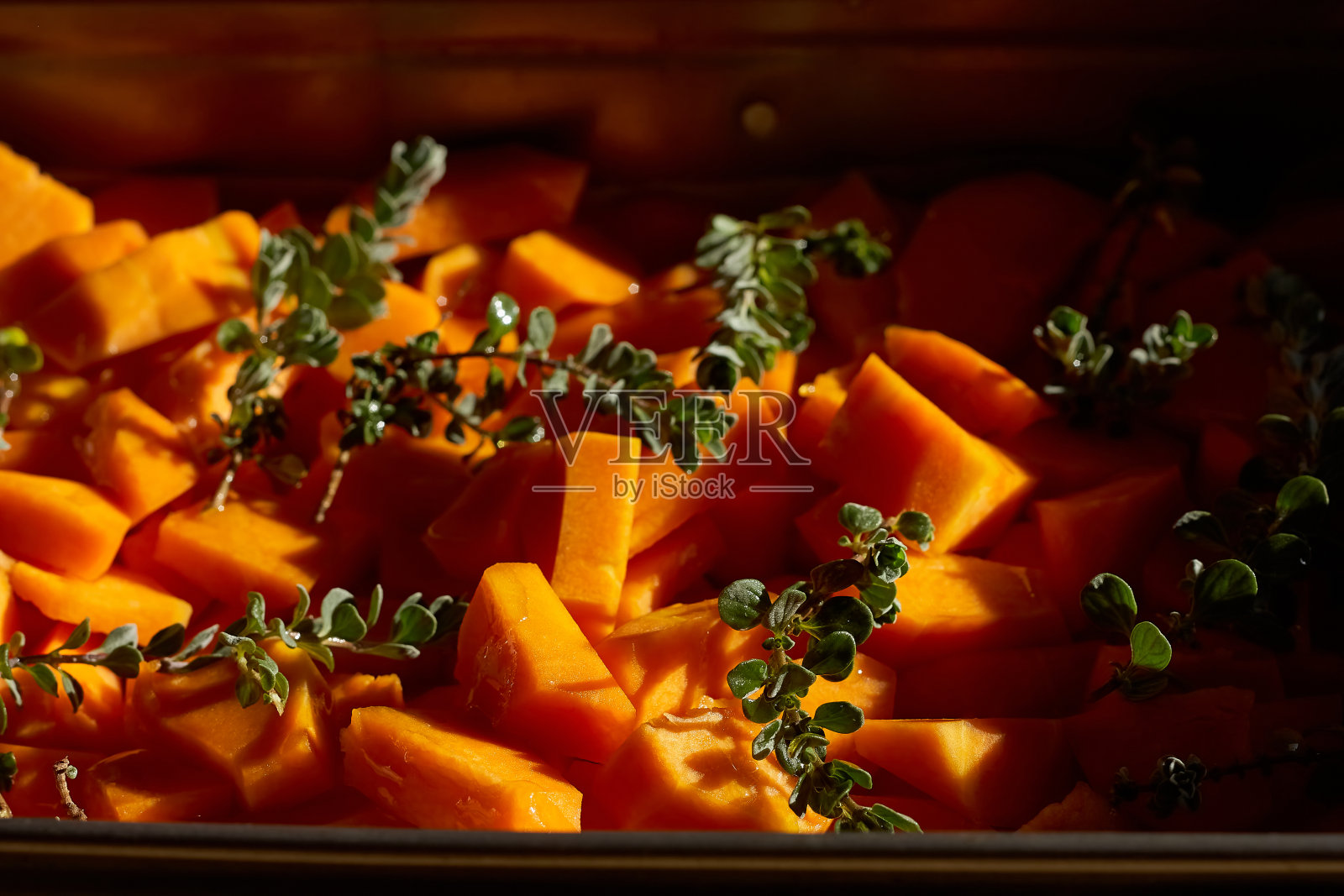 烤箱烤南瓜片配香草。健康的素食。Battenut壁球立方体。健康排毒晚餐。关闭了。照片摄影图片