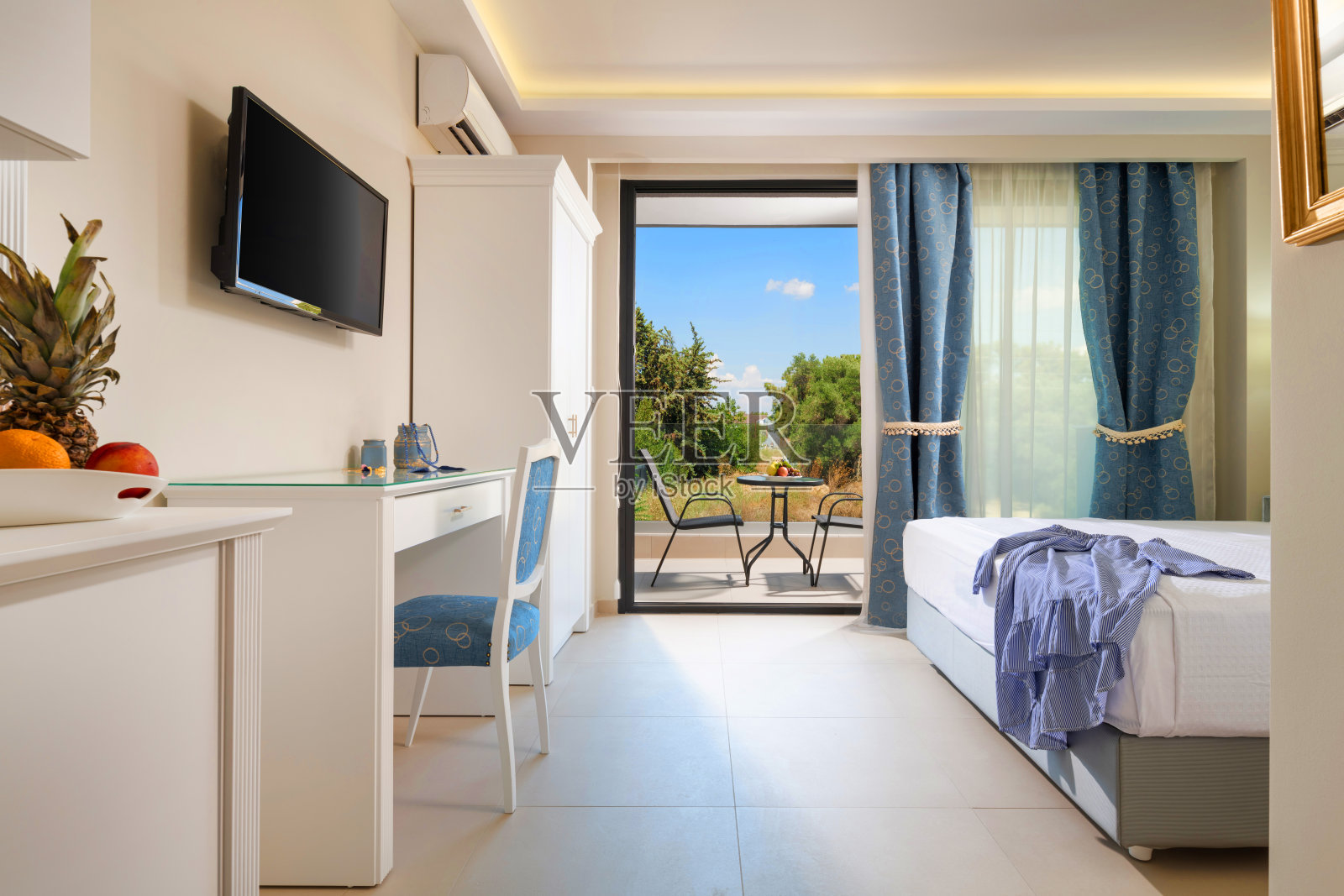 经典风格的漂亮的白色卧室内饰与大开窗玻璃门夏季花园景观与优雅的露台家具照片摄影图片