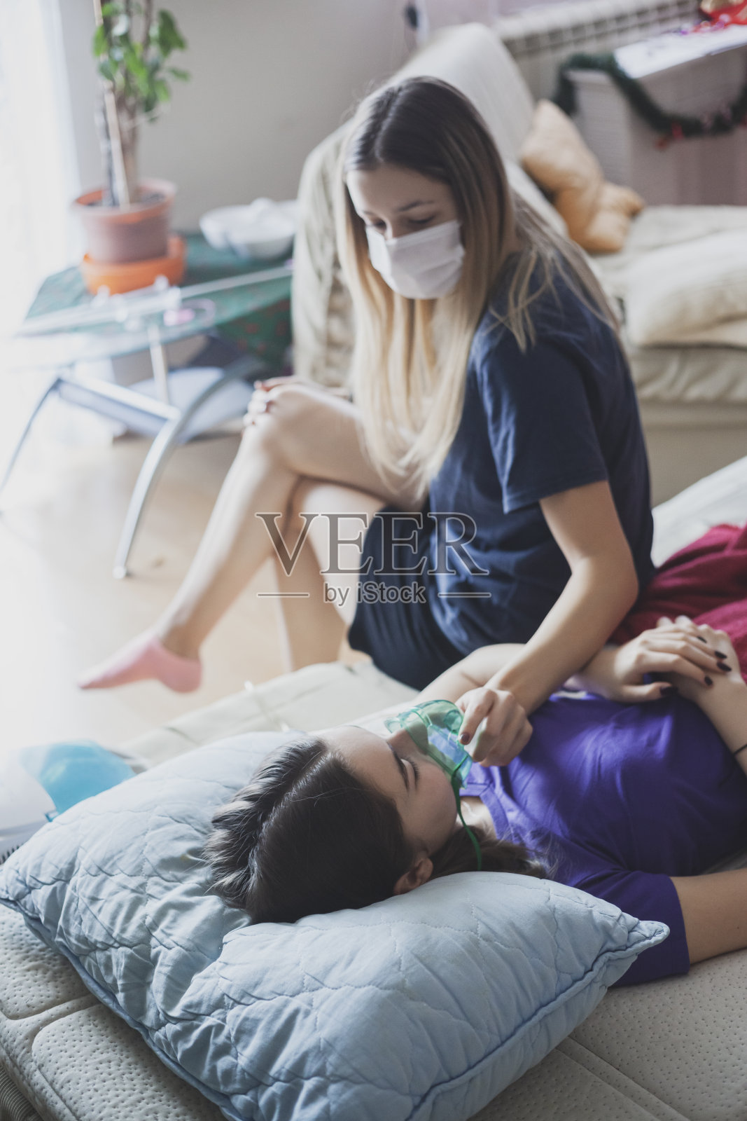 一名年轻女子帮助她感染冠状病毒的姐姐吸氧照片摄影图片