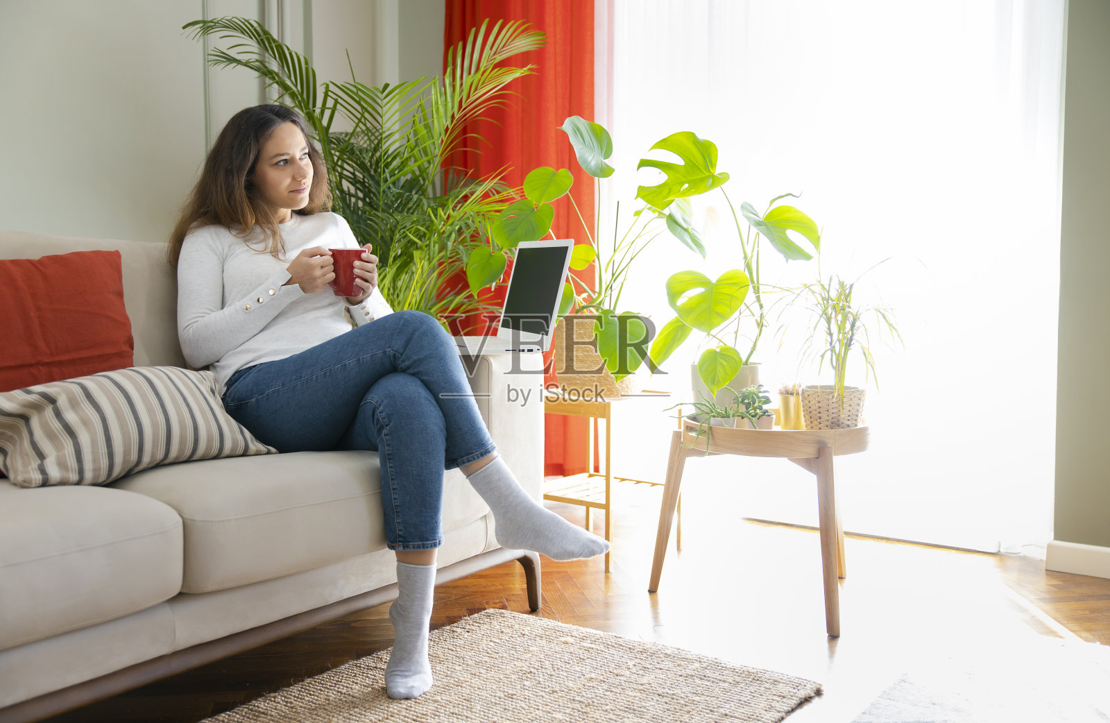 年轻女子坐在沙发上使用笔记本电脑照片摄影图片