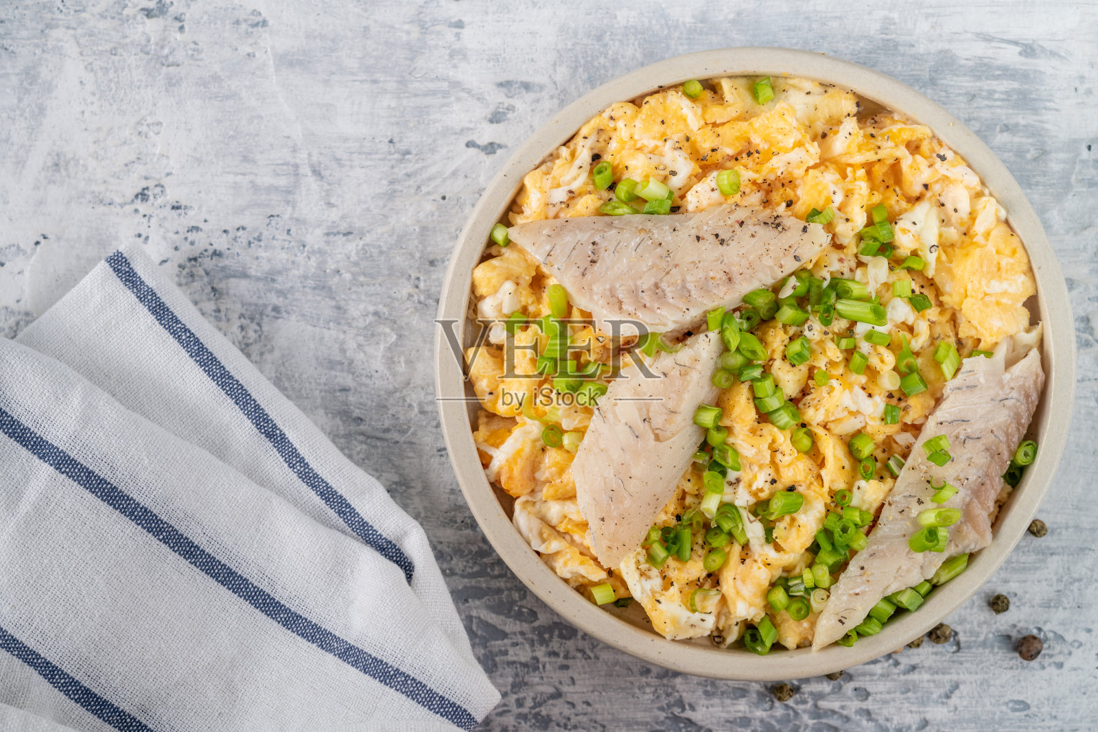 烟熏白鱼片配鲜葱煎蛋。早餐有馅的煎蛋卷。健康或生酮或无碳水化合物的食物概念。照片摄影图片