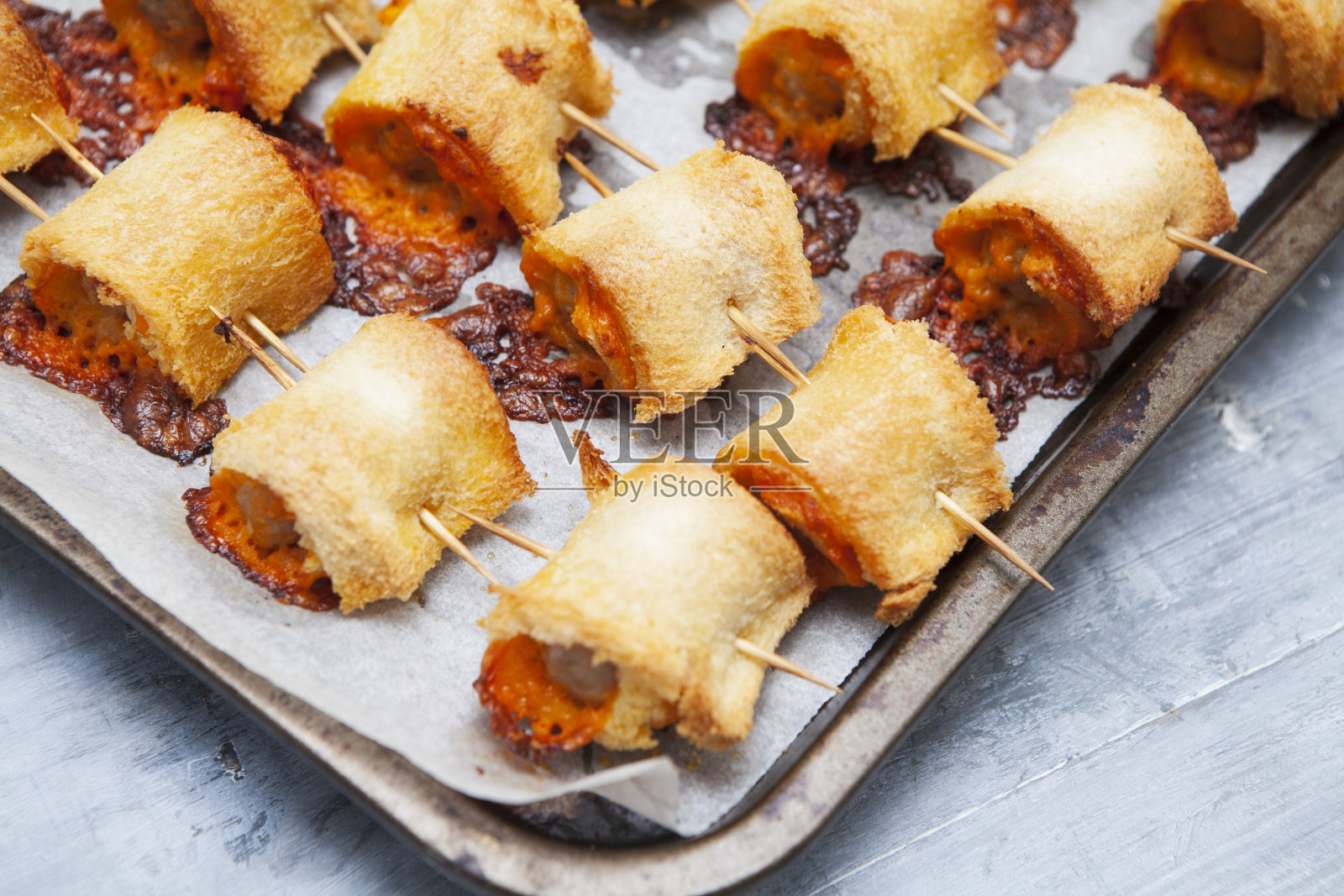 烤盘上的香肠卷在灰色的木头表面上照片摄影图片