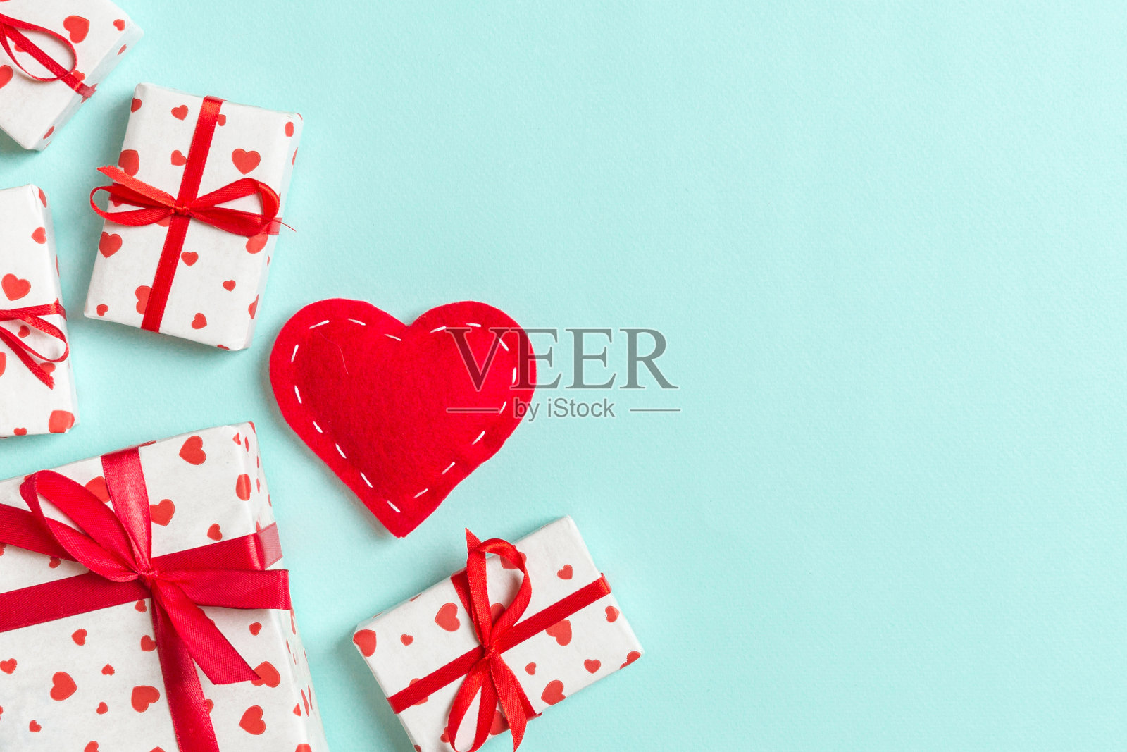 顶视图的礼品盒和红色的纺织心在彩色的背景。情人节概念与拷贝空间照片摄影图片